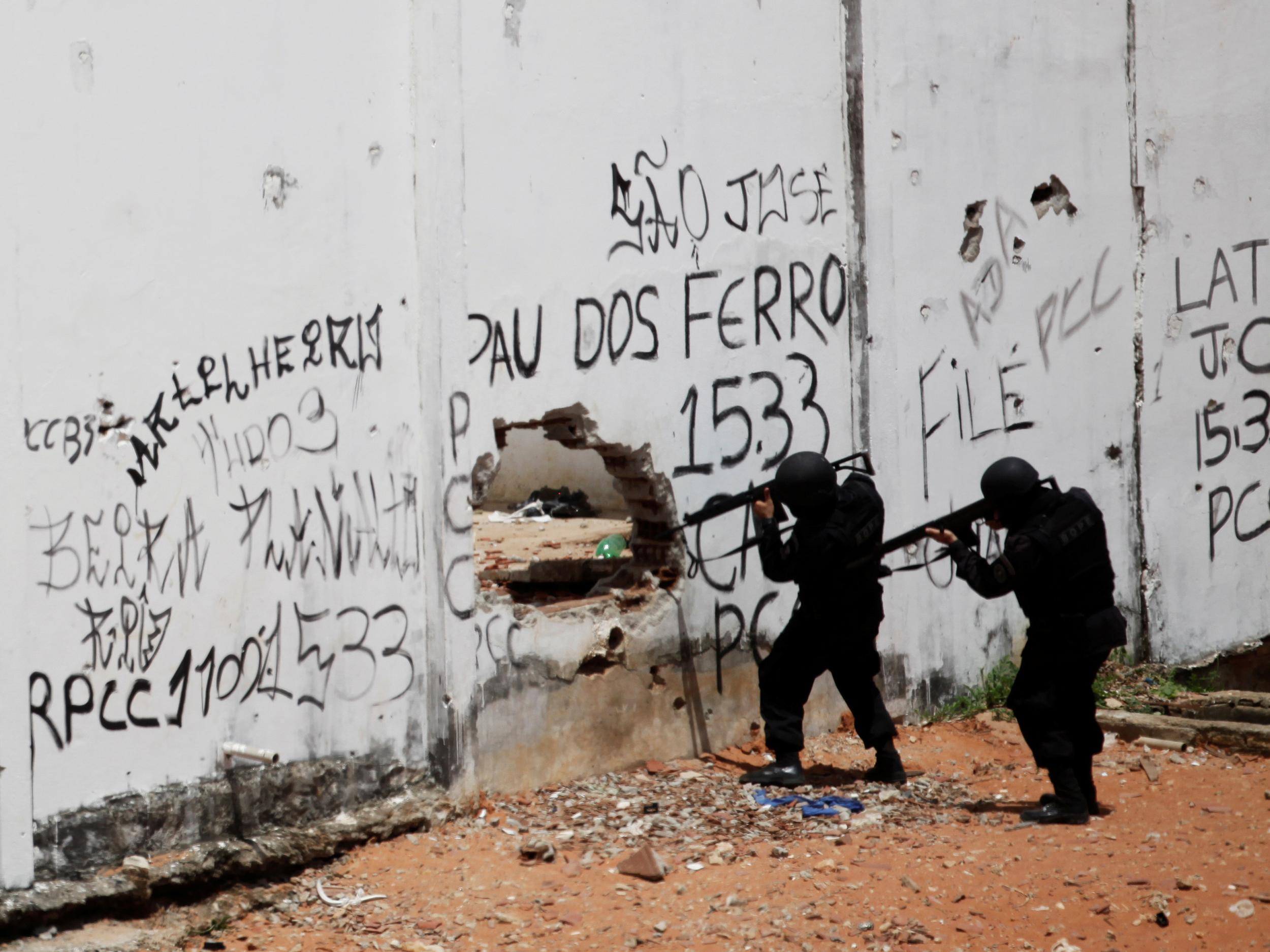Riot policemen carry weapons during an uprising at Alcacuz prison in Natal, Brazil