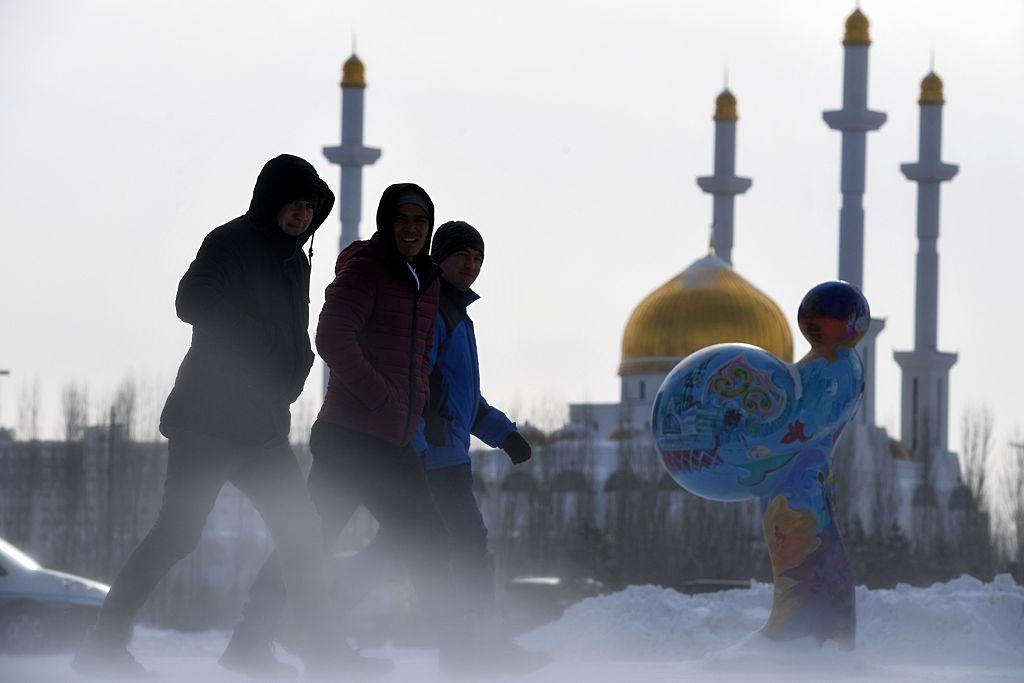 Men walk along a street in Astana on January 22, 2017. The so-called Astana peace talks, set to begin on Monday, will be the first time a delegation composed exclusively of rebel groups will negotiate with the regime of Syrian President Bashar al-Assad