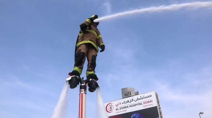 A firefighter using a jetpack tackles a blaze from above