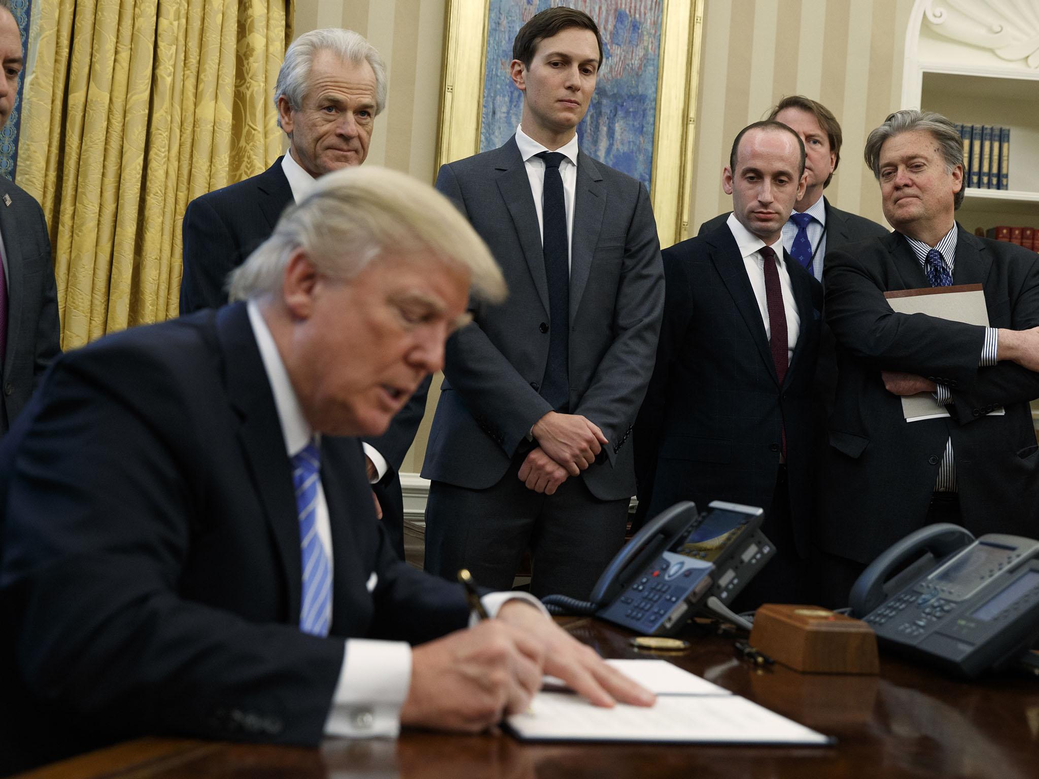 From left, White House Chief of Staff Reince Priebus, National Trade Council adviser Peter Navarro, Senior Adviser Jared Kushner, policy adviser Stephen Miller, and chief strategist Steve Bannon watch as President Donald Trump signs an executive order in the Oval Office of the White House