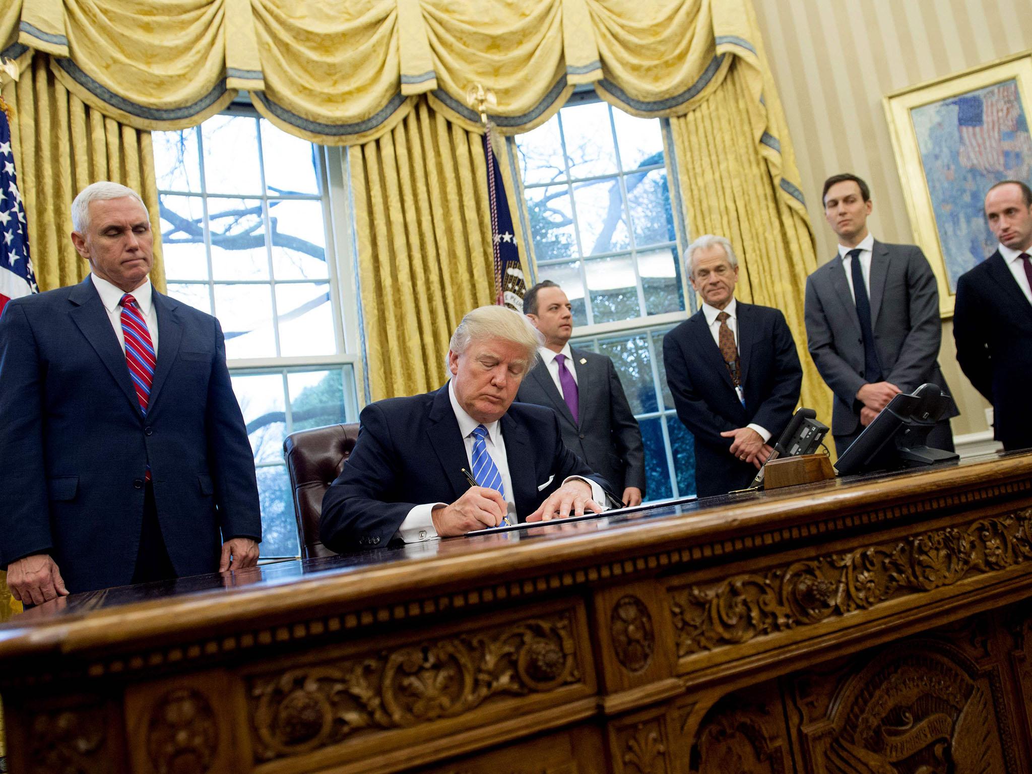 The image of Ms Lovin signing the emissions order appeared to be a reference to this image of Mr Trump, surrounded by men, signing an executive order hitting foreign NGOs that help women have abortions