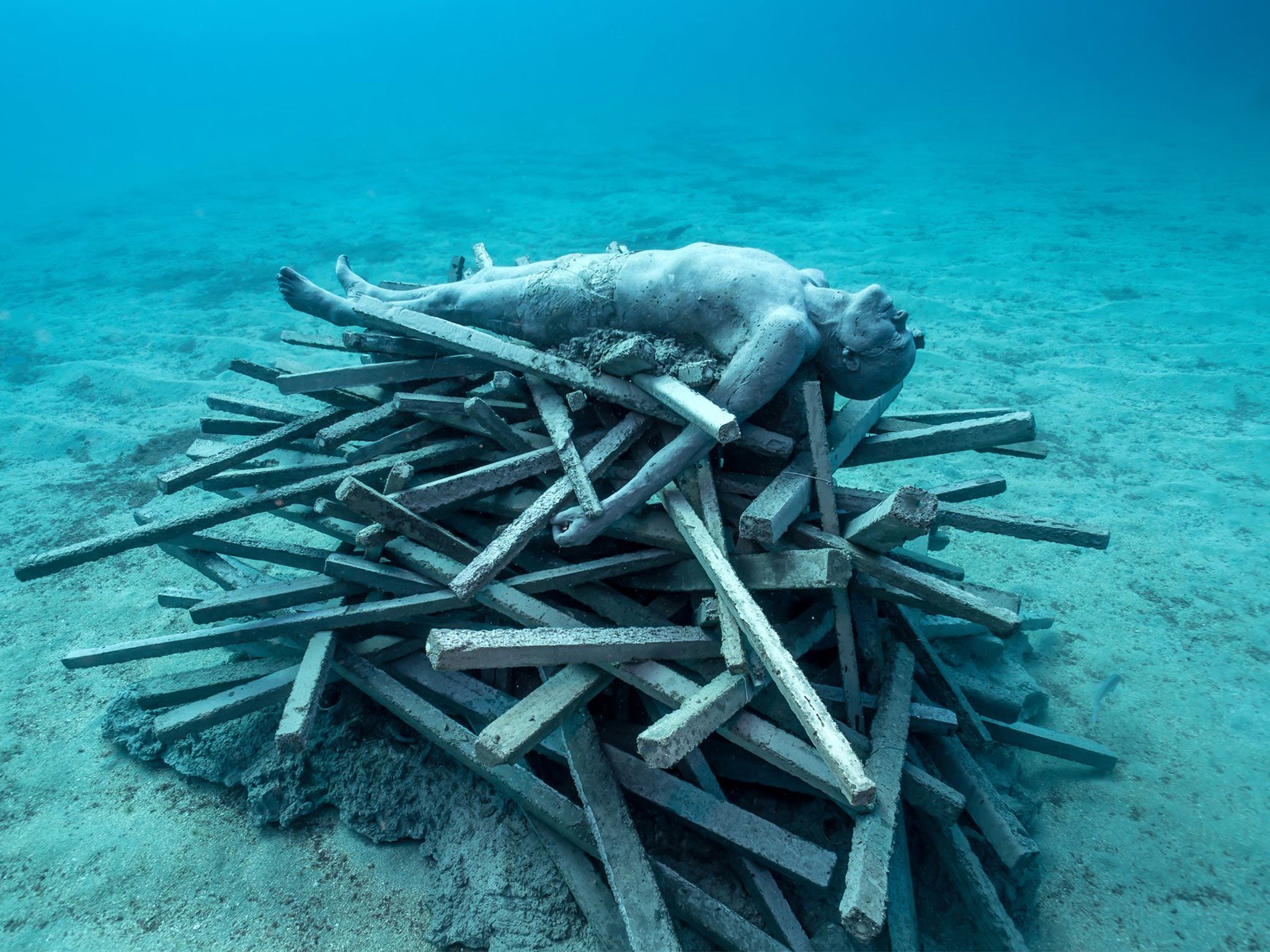 The Immortal Pyre depicts a funeral pyre. While the sculpture represents the departure of life, the concrete sticks that make up the firewood have been designed as a habitat for marine life.