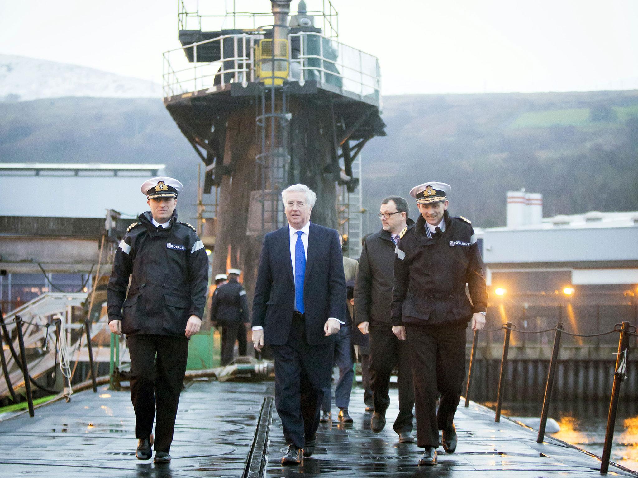 Defence Secretary Michael Fallon, seen here atop a Trident nuclear submarine, has said Jeremy Corbyn is "gutless" for opposing military expansion