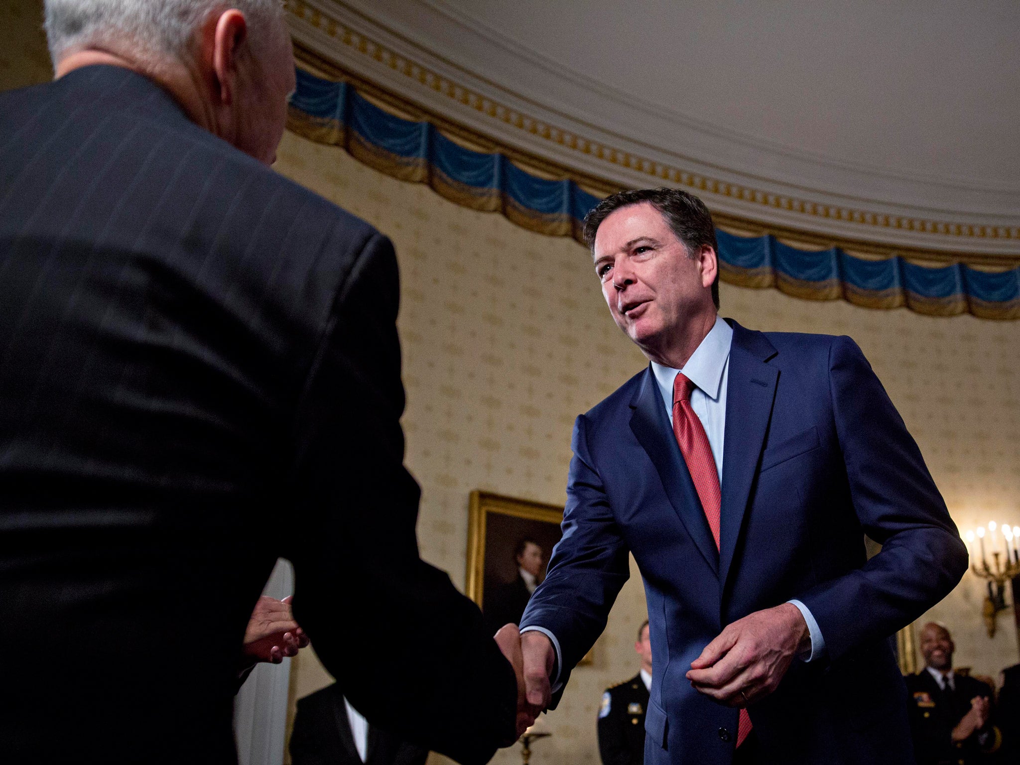 Comey shakes hands with Vice President Pence during a law enforcement Inaugural reception