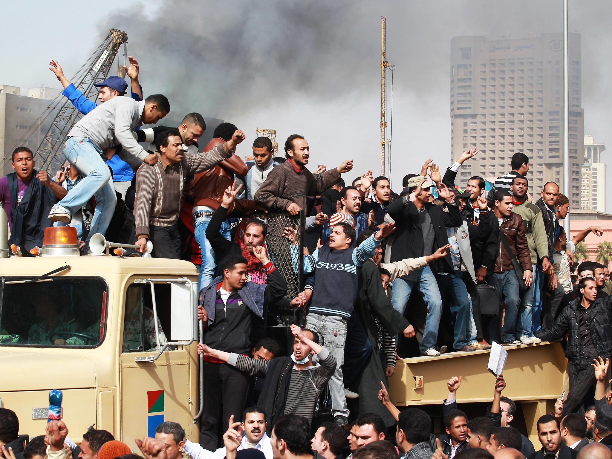 Protestors chant as they ride on an army tank transporter in Cairo’s Tahrir Square in January 2011