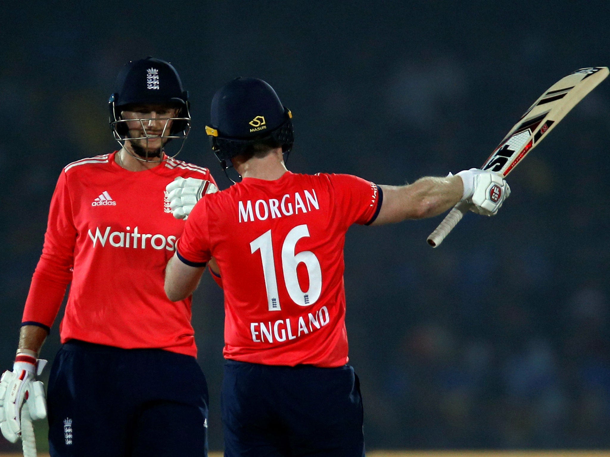 England's captain Eoin Morgan (R) celebrates his half century with his team-mate Joe Root