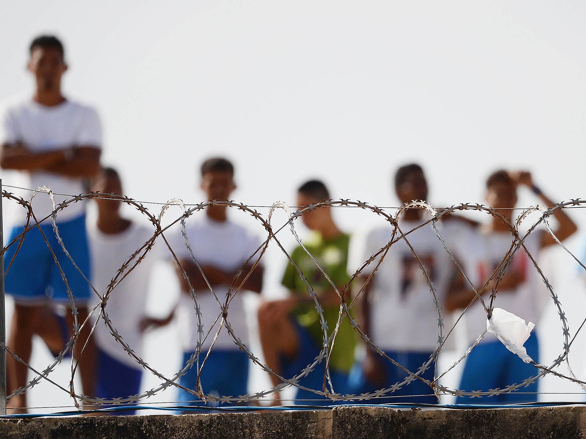 Inmates watch as injured prisoners are removed to receive medical care the day after a battle between gangs in the Alcacuz Penitentiary Centre