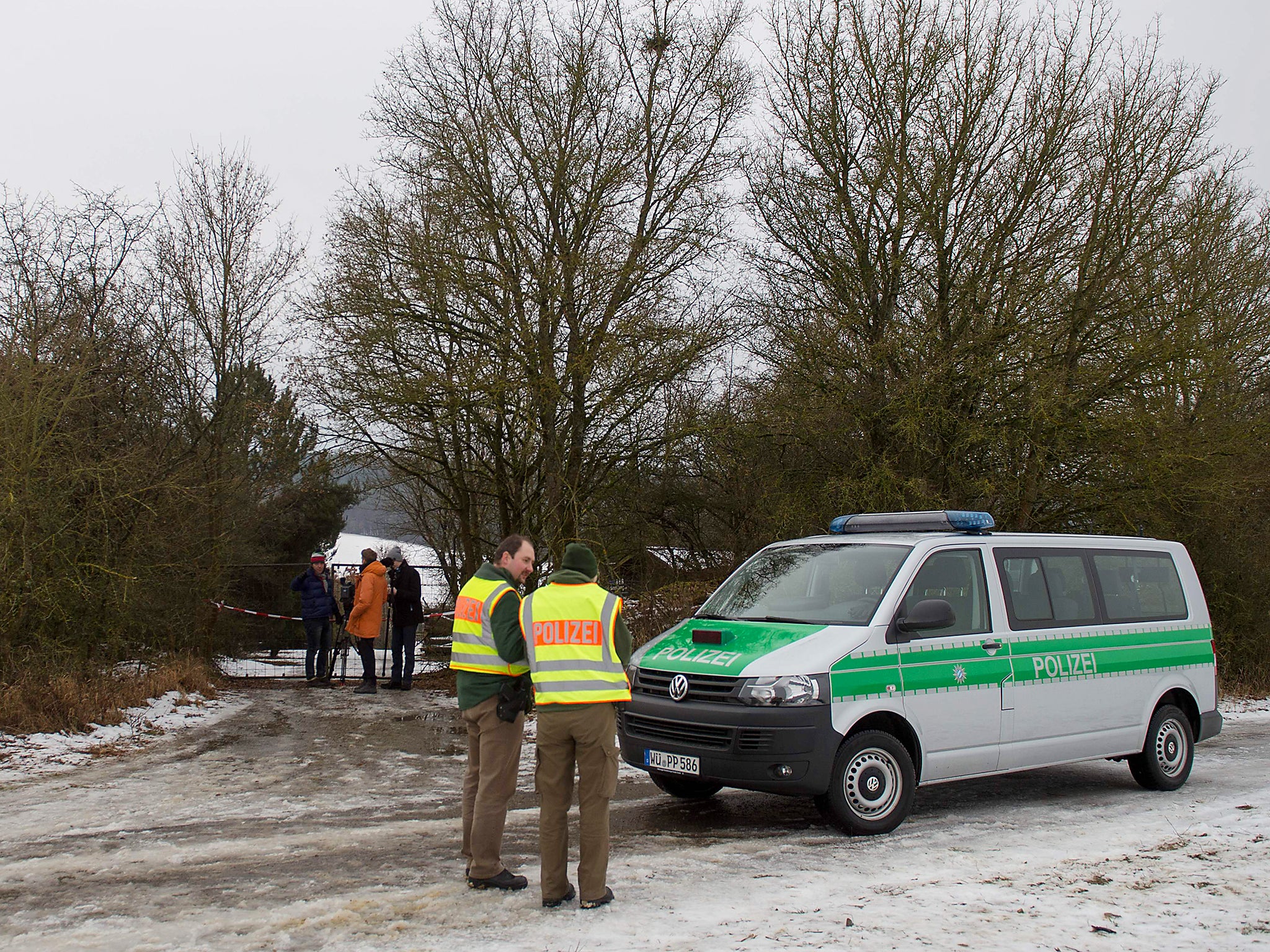 Police officers and journalists outside the home where six teenagers including a brother and sister were found dead