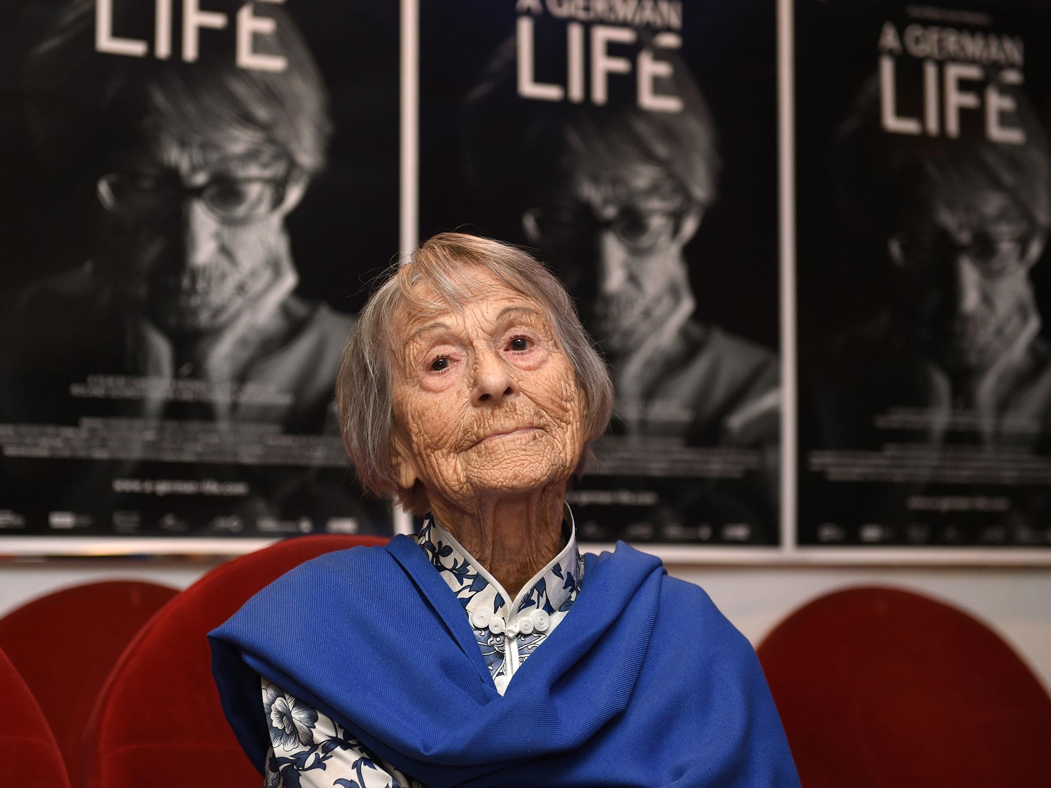 Brunhilde Pomsel, former secretary of Nazi propaganda chief Joseph Goebbels, sits on a cinema chair in front of posters for the movie 'A German life'