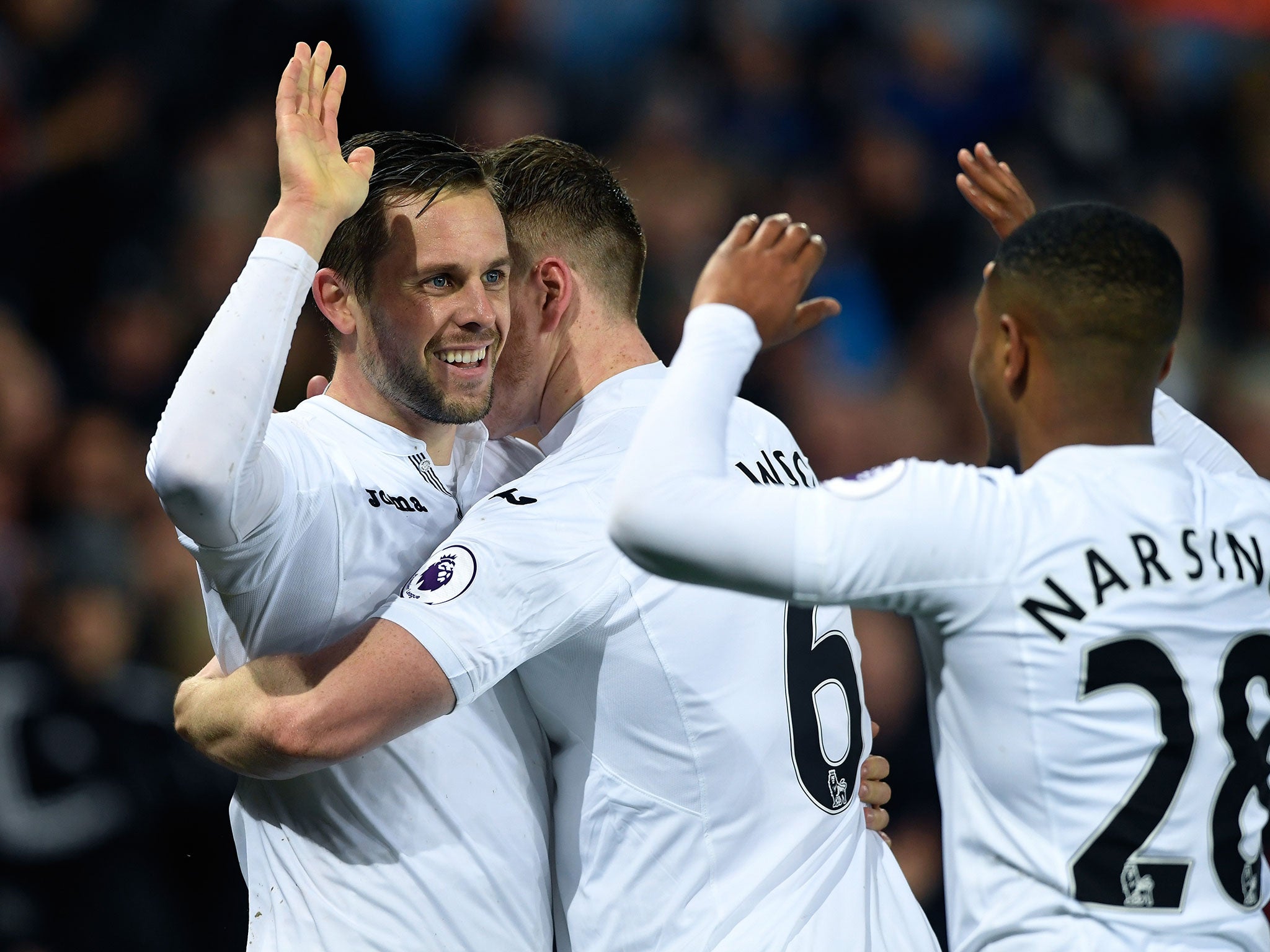 Gylfi Sigurdsson celebrates with his team-mates after scoring Swansea's second