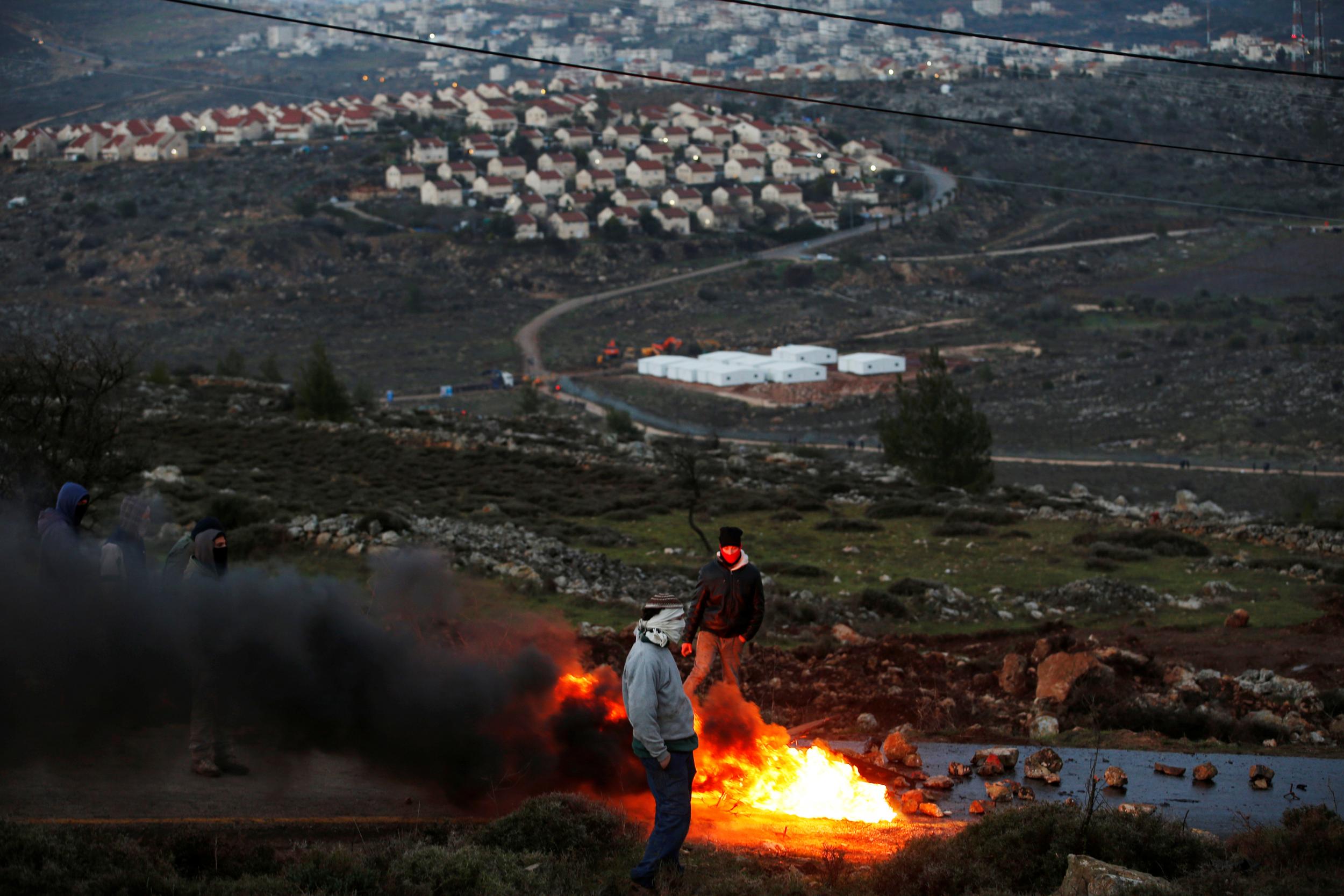 Protesters burn tires at the entrance to the Israeli settler outpost of Amona in the occupied West Bank early in the morning of February 1, 2017