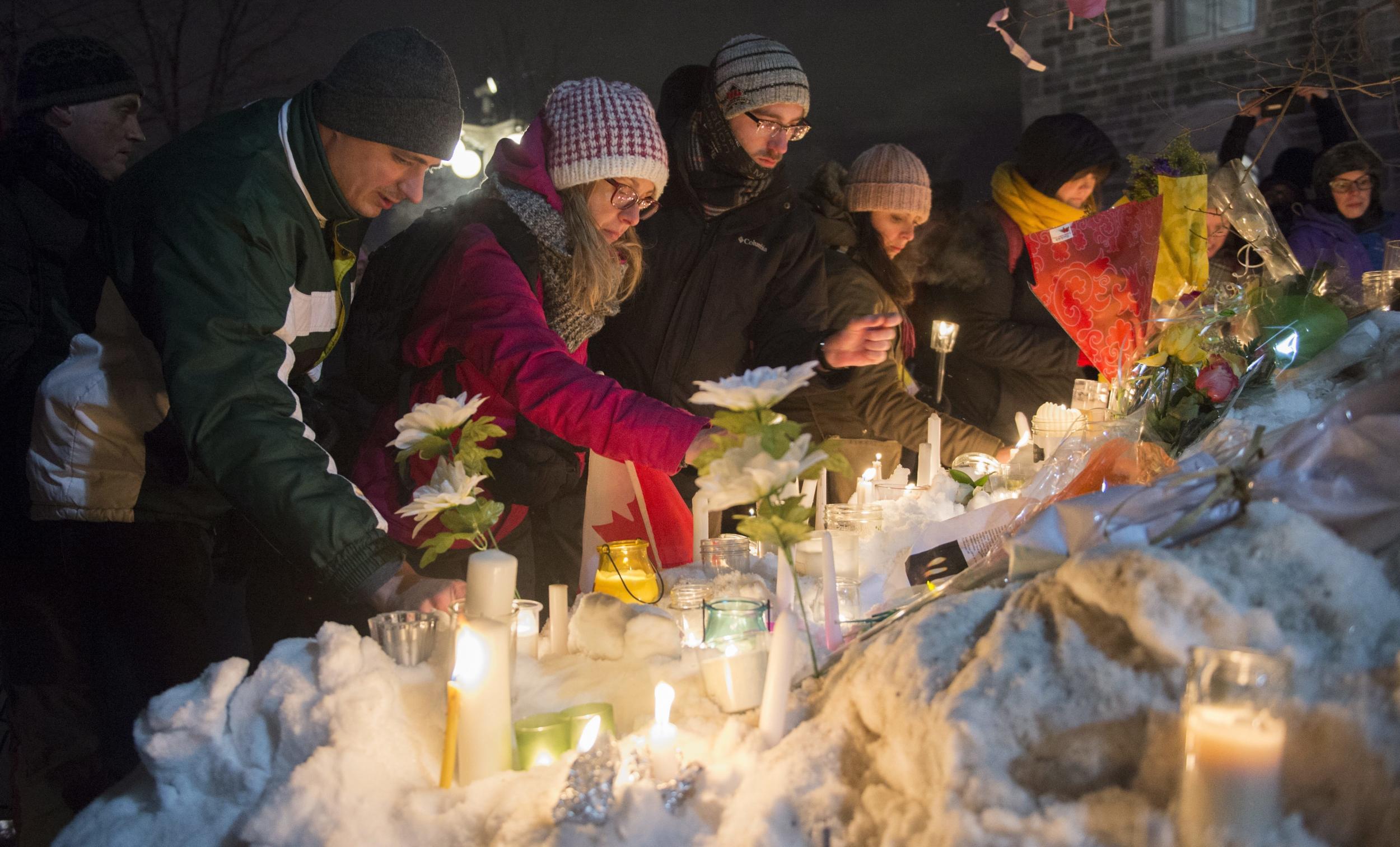 People place candles during a vigil in Quebec City on Monday for victims of Sunday's deadly shooting at a Quebec City mosque