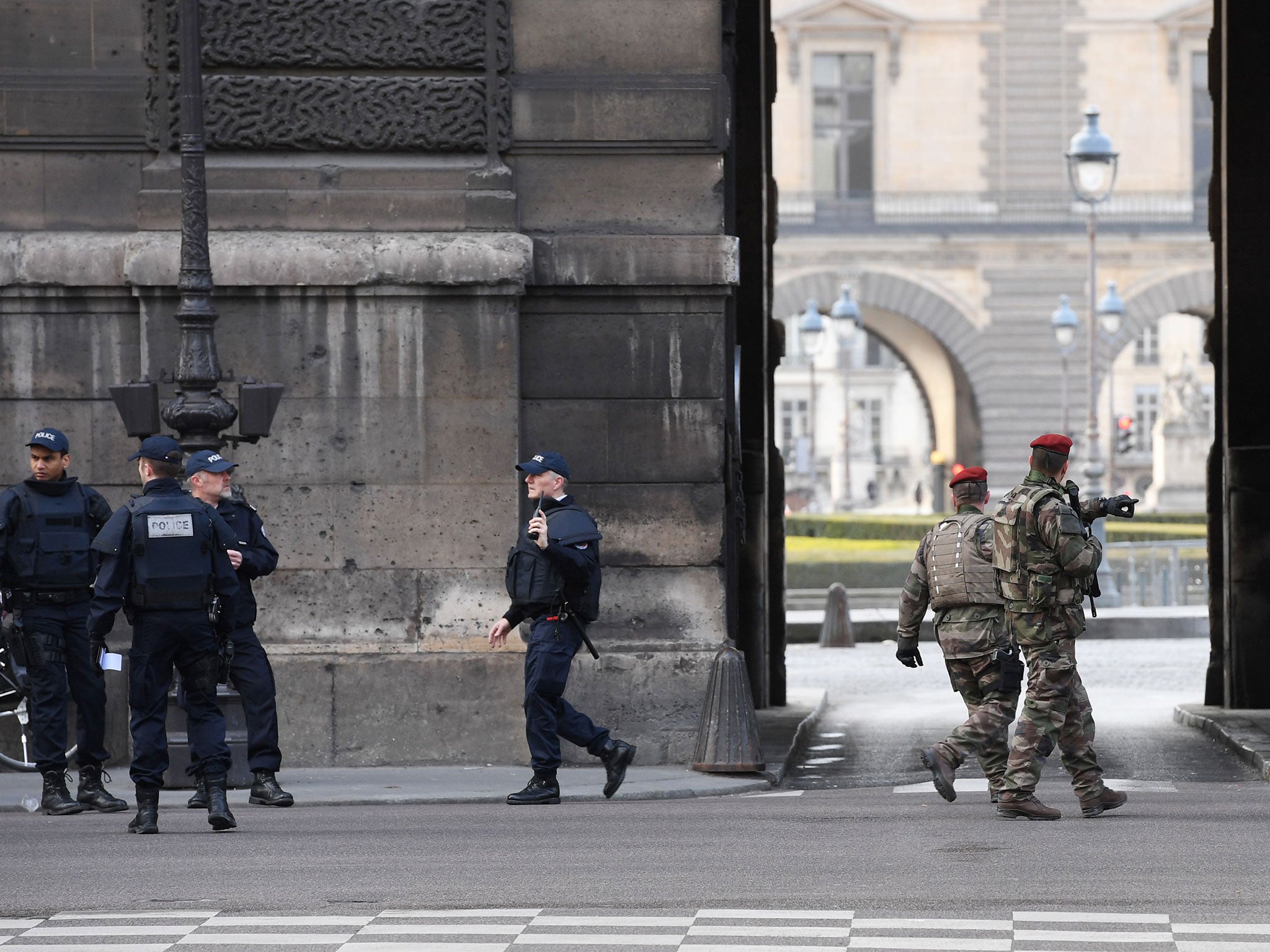 French police officers and soldiers patrol in front of Le Louvre museum after an attempted attack on a soldier on 3 February