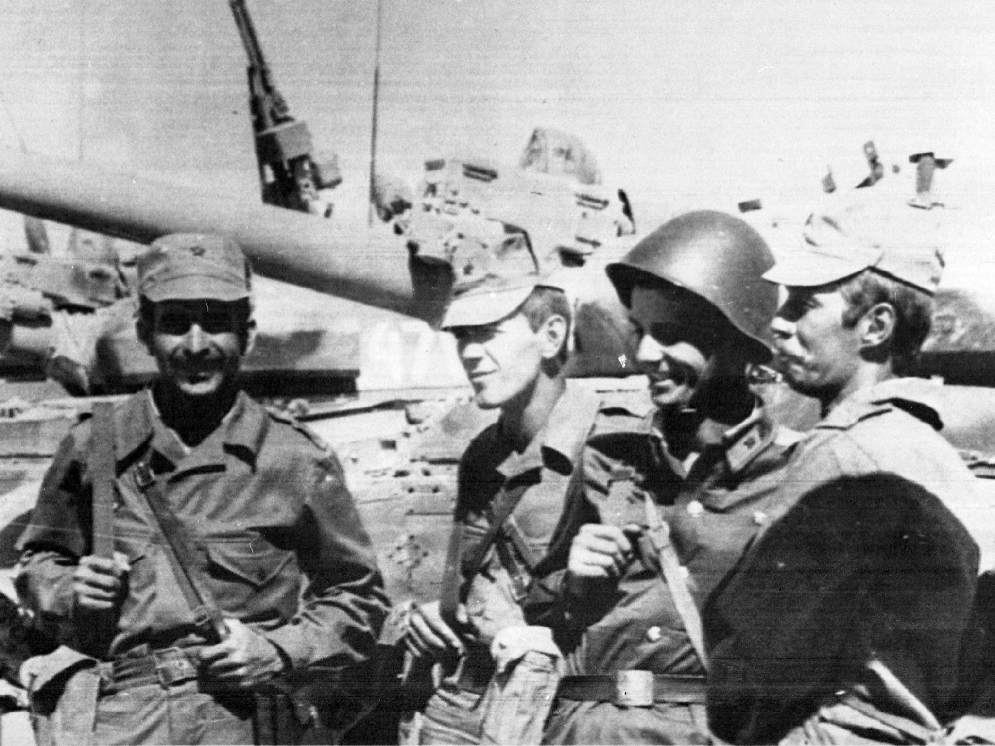 Soviet soldiers stand in front of their tanks as they take one final look at local scenery in Afghanistan in 1986