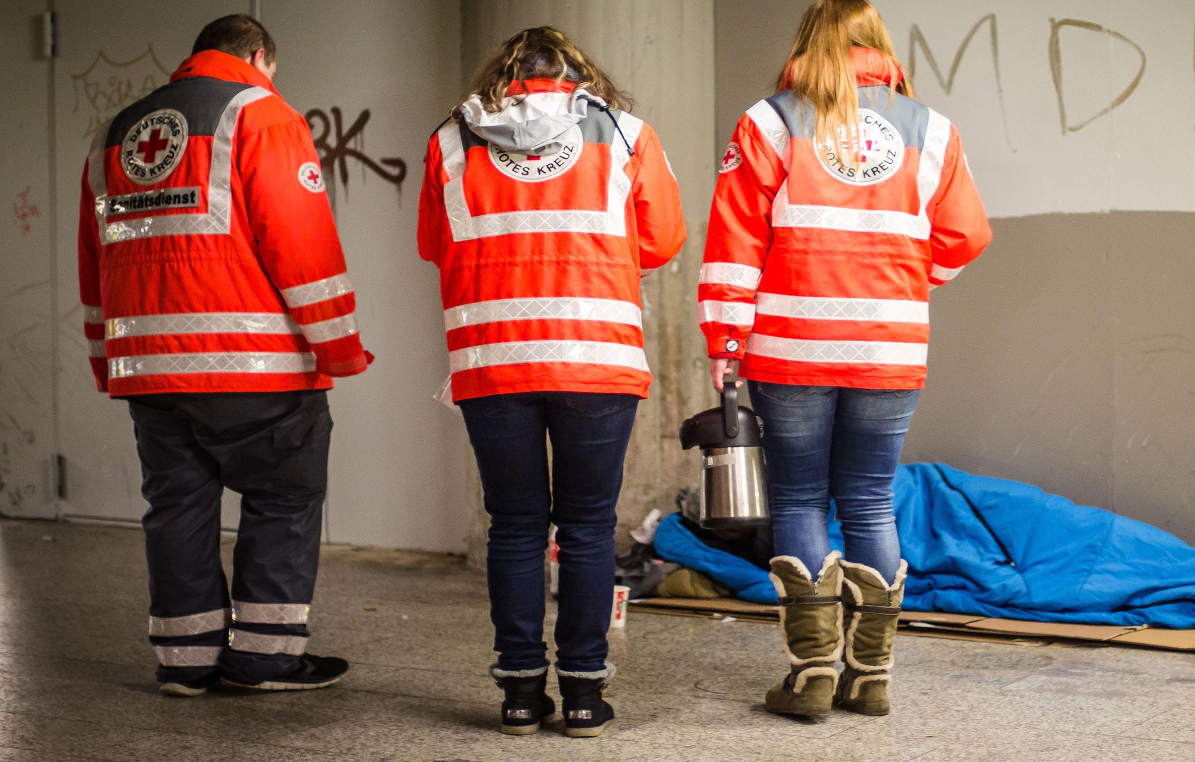 Red Cross volunteers help a homeless man