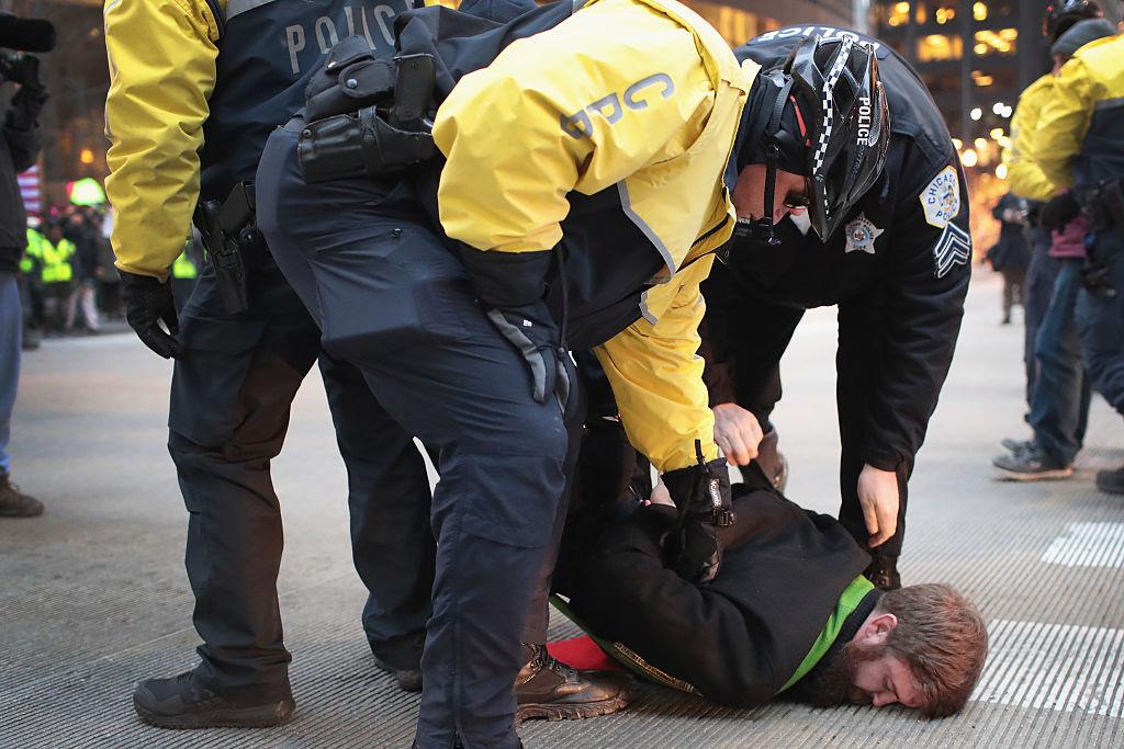 Police arrest an anti-Trump protestor for blocking traffic in downtown Chicago