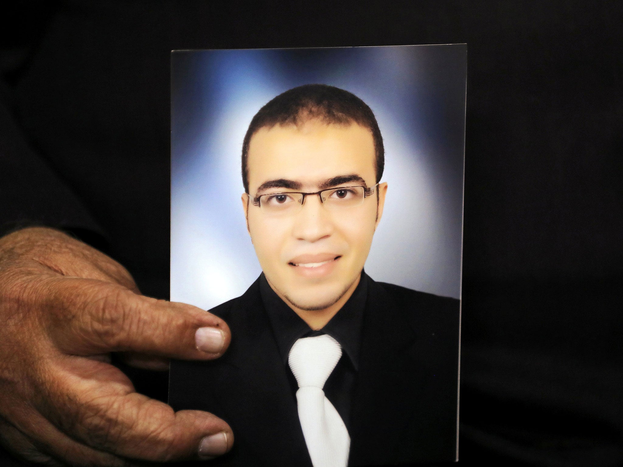 Reda Abdullah al-Hamamy, the father of Abdullah Reda al-Hamamy who is suspected of attacking a soldier in Paris' Louvre museum, holds a picture of his son in Egypt on 4 February