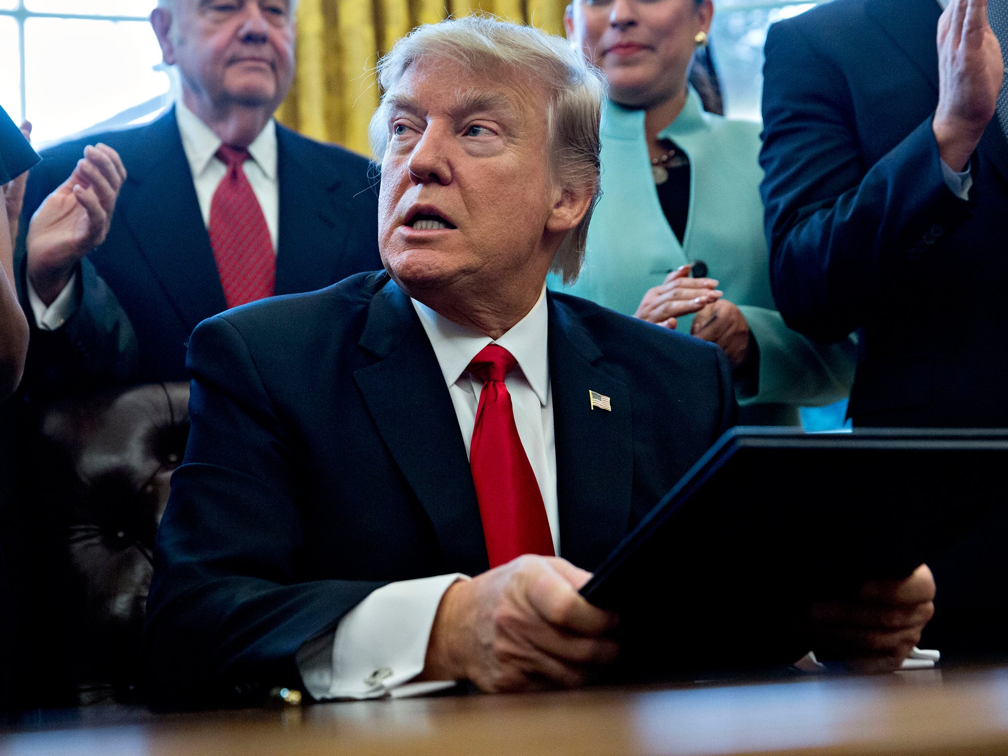 President Trump signs an executive order in the Oval Office