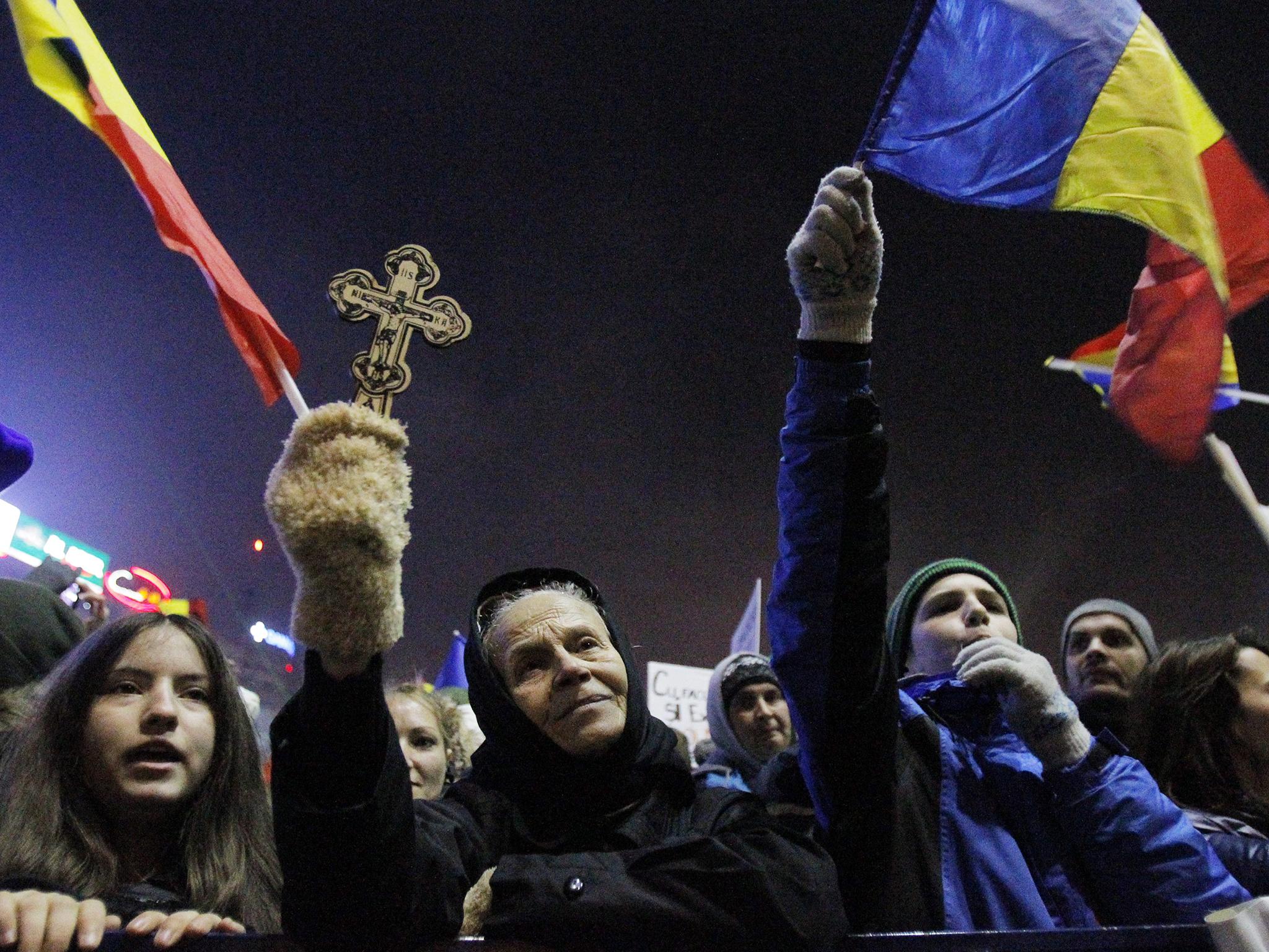 People attend a protest in front of government headquarters in Bucharest, Romania