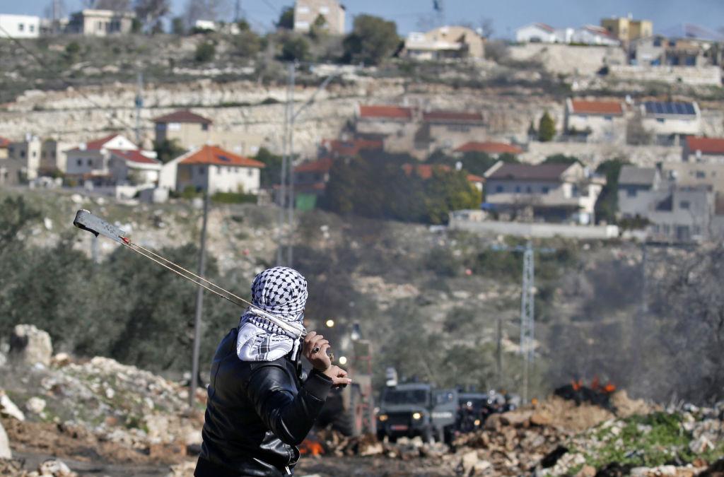 A Palestinian protester uses a slingshot to hurl stones towards Israeli security forces during clashes near Nablus, in the occupied West Bank, following a weekly demonstration against the expropriation of Palestinian land by Israel on February 3, 2017