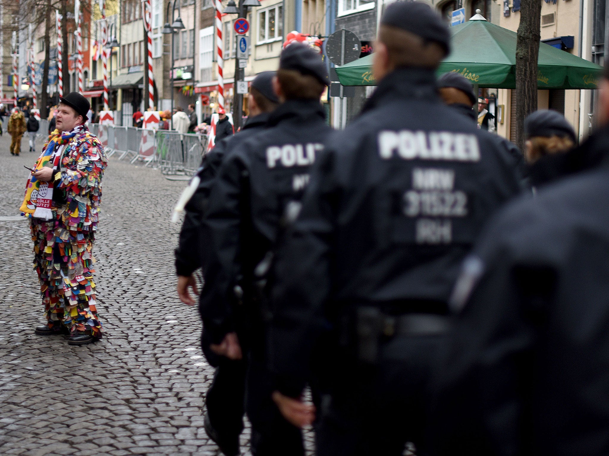 Police officers pass a clown during a carnival parade on 7 February 2016 in Cologne, Germany