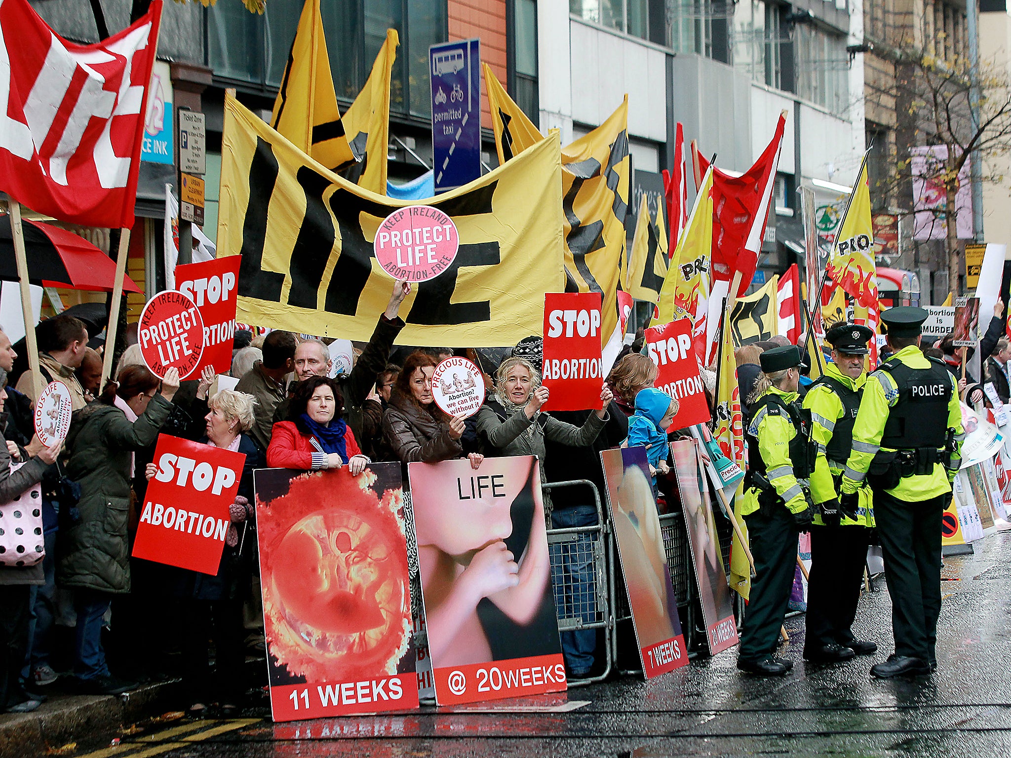 Police walk around abortion protestors holding up placards outside the Marie Stopes clinic, the first private clinic to offer abortions to women in Belfast, Northern Ireland