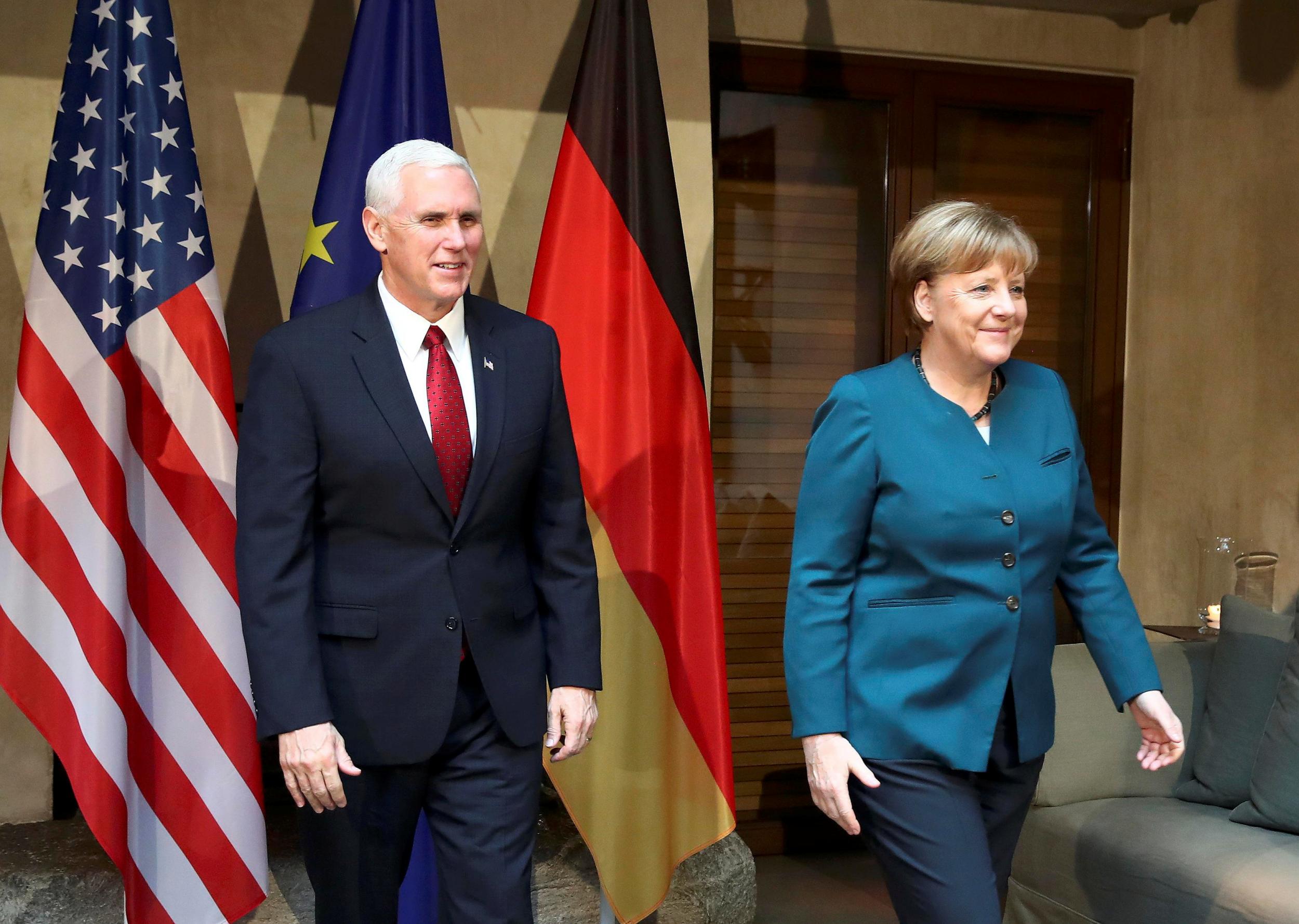 Angela Merkel walks with US Vice President Mike Pence before their meeting at the Munich Security Conference