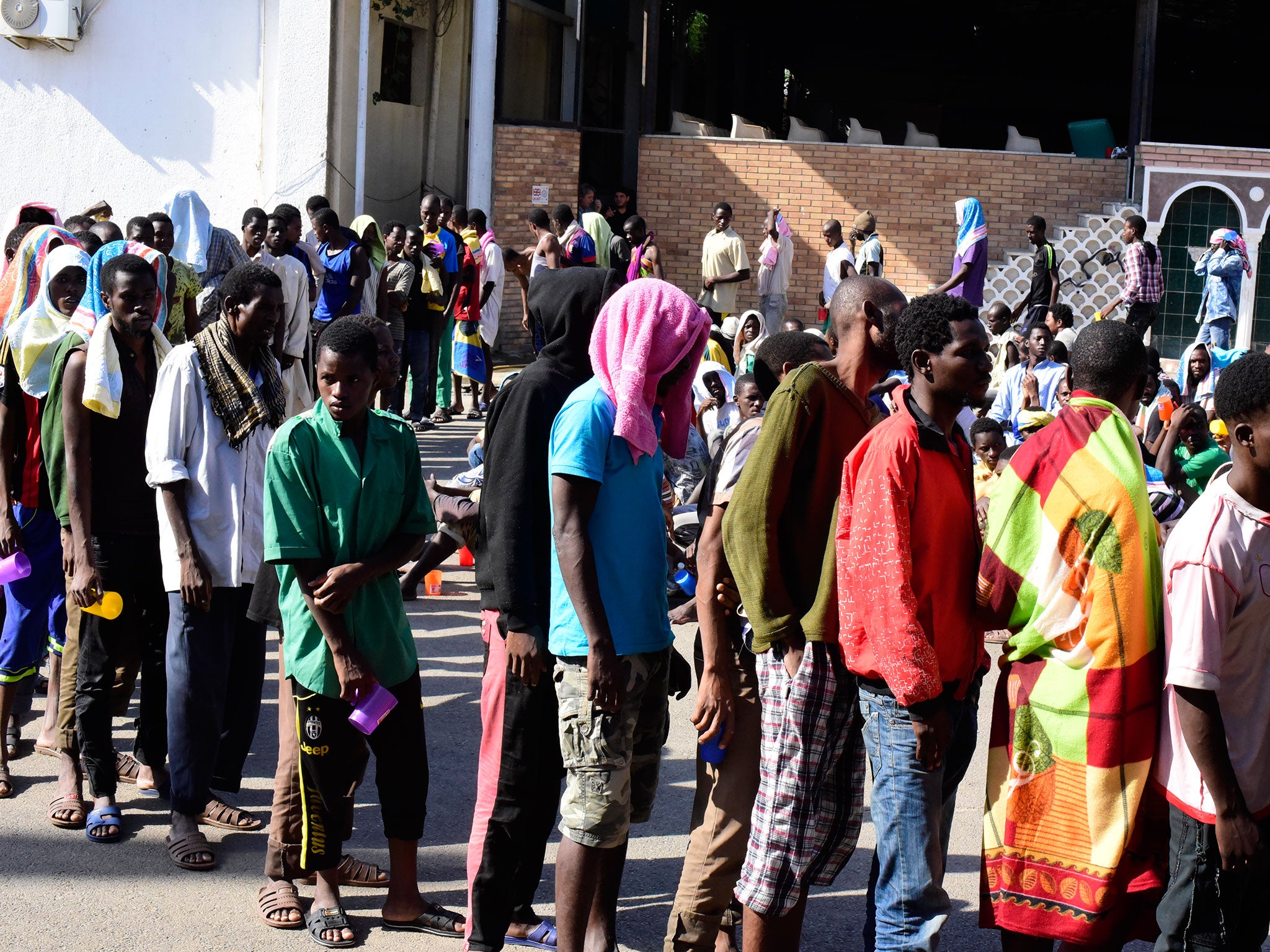 Men queuing for food a the Fallah migrant detention centre near Tripoli, Libya