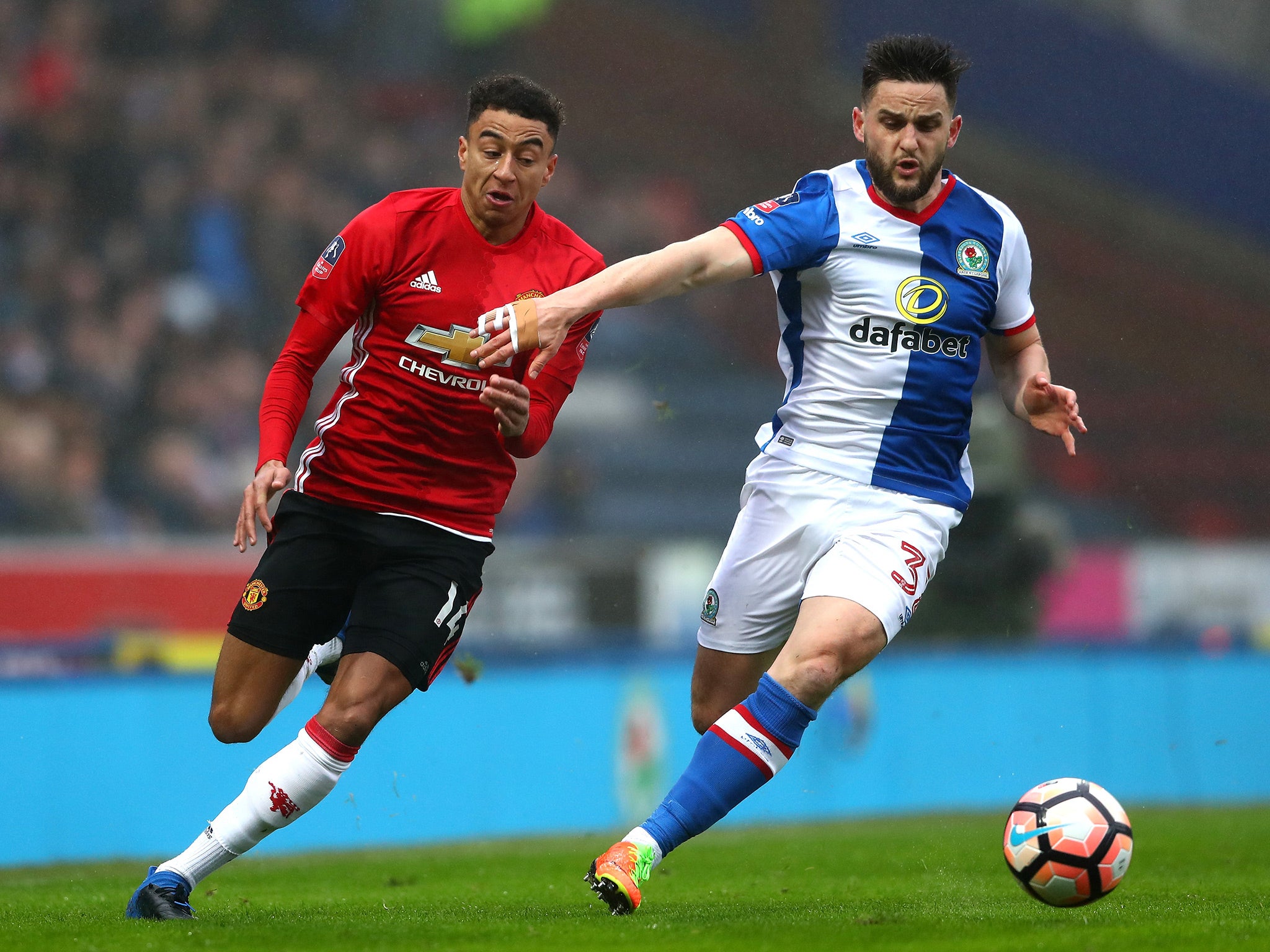 Jesse Lingard and Craig Conway battle for the ball in the opening stages at Ewood Park