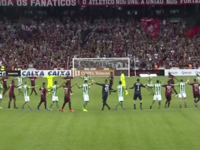 Coritiba and Atletico players salute the crowd as their derby is postponed