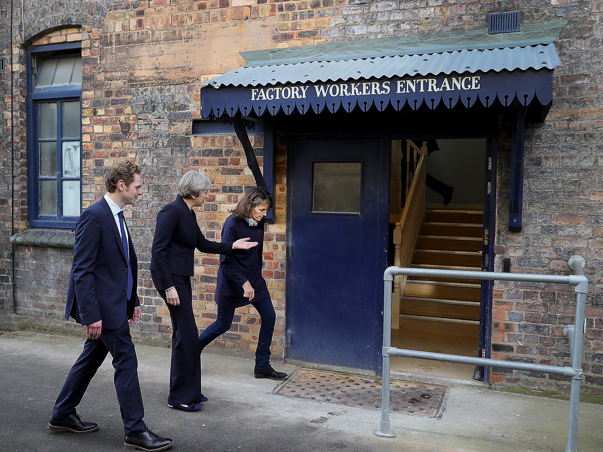 British Prime Minister Theresa May is escorted by Emma Bridgewater and Stoke Central by-election candidate Jack Brereton, as she arrives at the Emma Bridgewater pottery factory in Hanley, Stoke-On-Trent, England