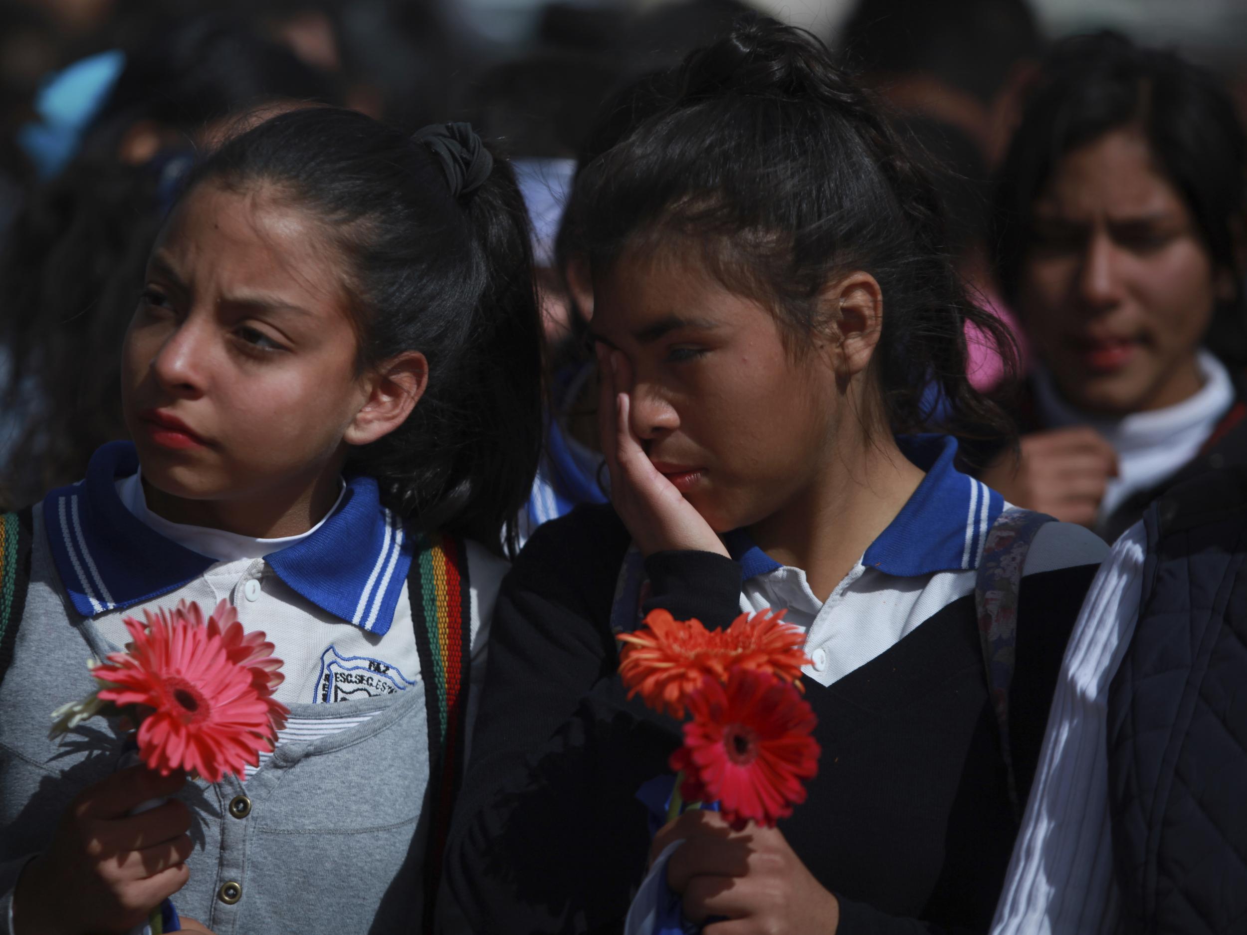 Mexicans students stand together as they form a symbolic human wall along the Rio Grande in protest at Donald Trump's immigration policies