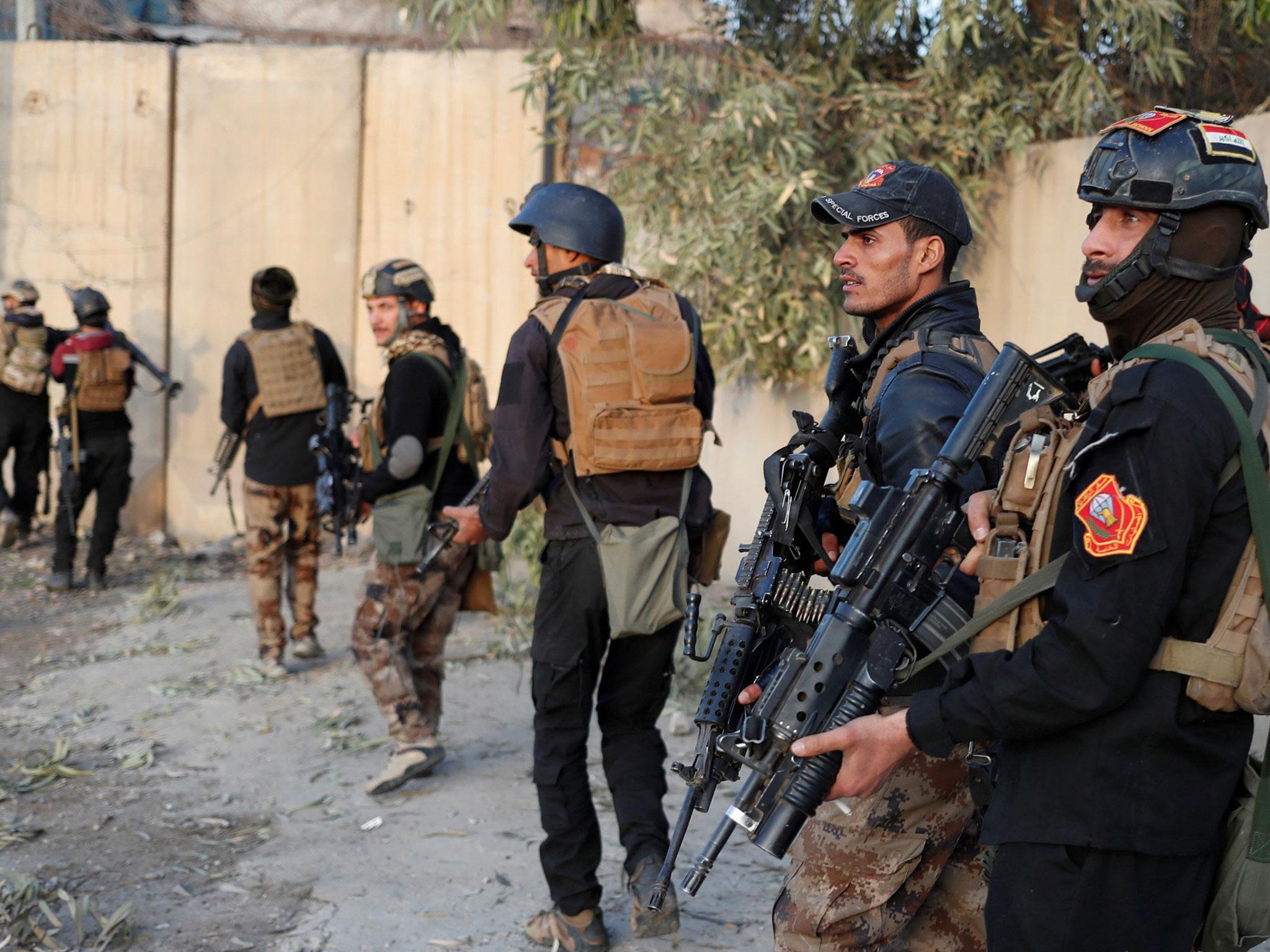 Iraqi Special Forces soldiers walk on a street during a battle with Isis fighters in Mosul, Iraq