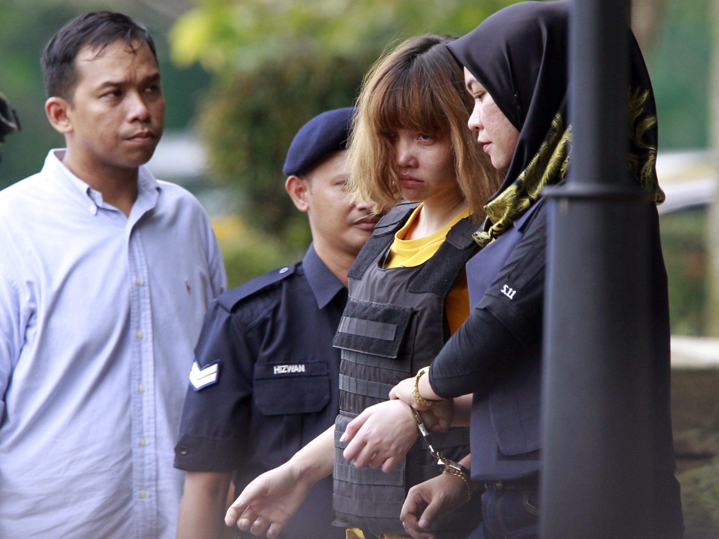 Vietnamese suspect Doan Thi Huong is escorted by police officers out of court