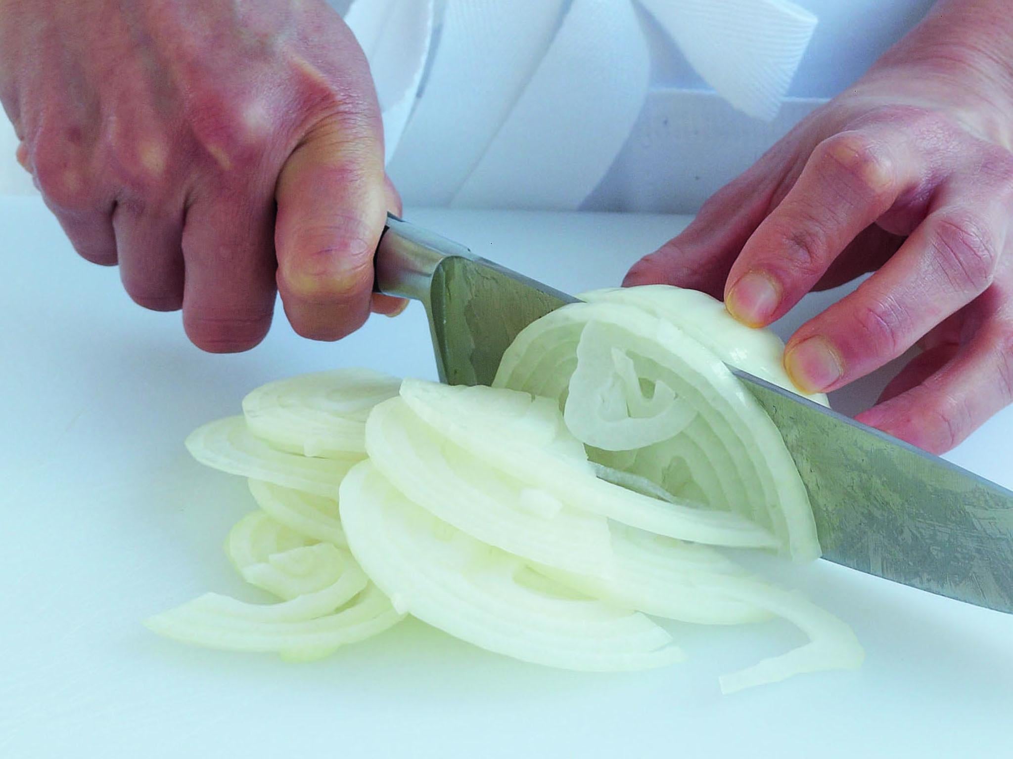 2. Slice the onion in a rocking action, keeping the tip of the knife in contact with the board as you draw it down to cut through the onion