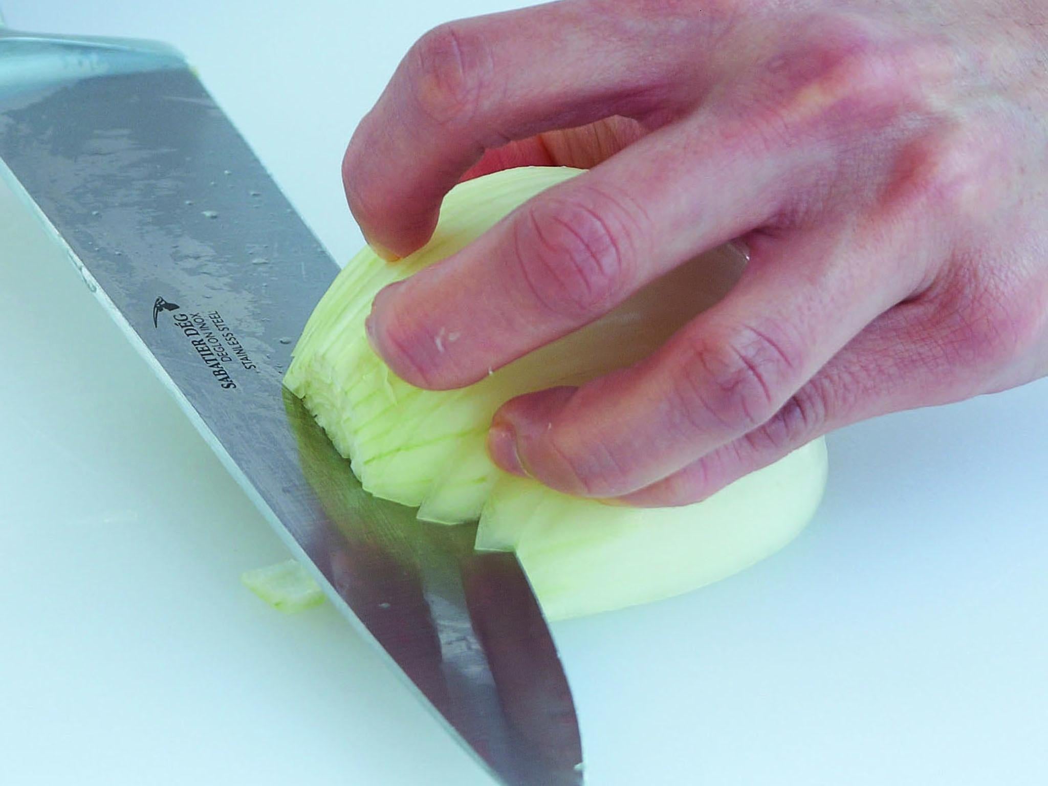 2. Slice horizontally through the onion once or twice, again not right through the root, but very close to it, keeping the knife slightly angled towards the board for safety