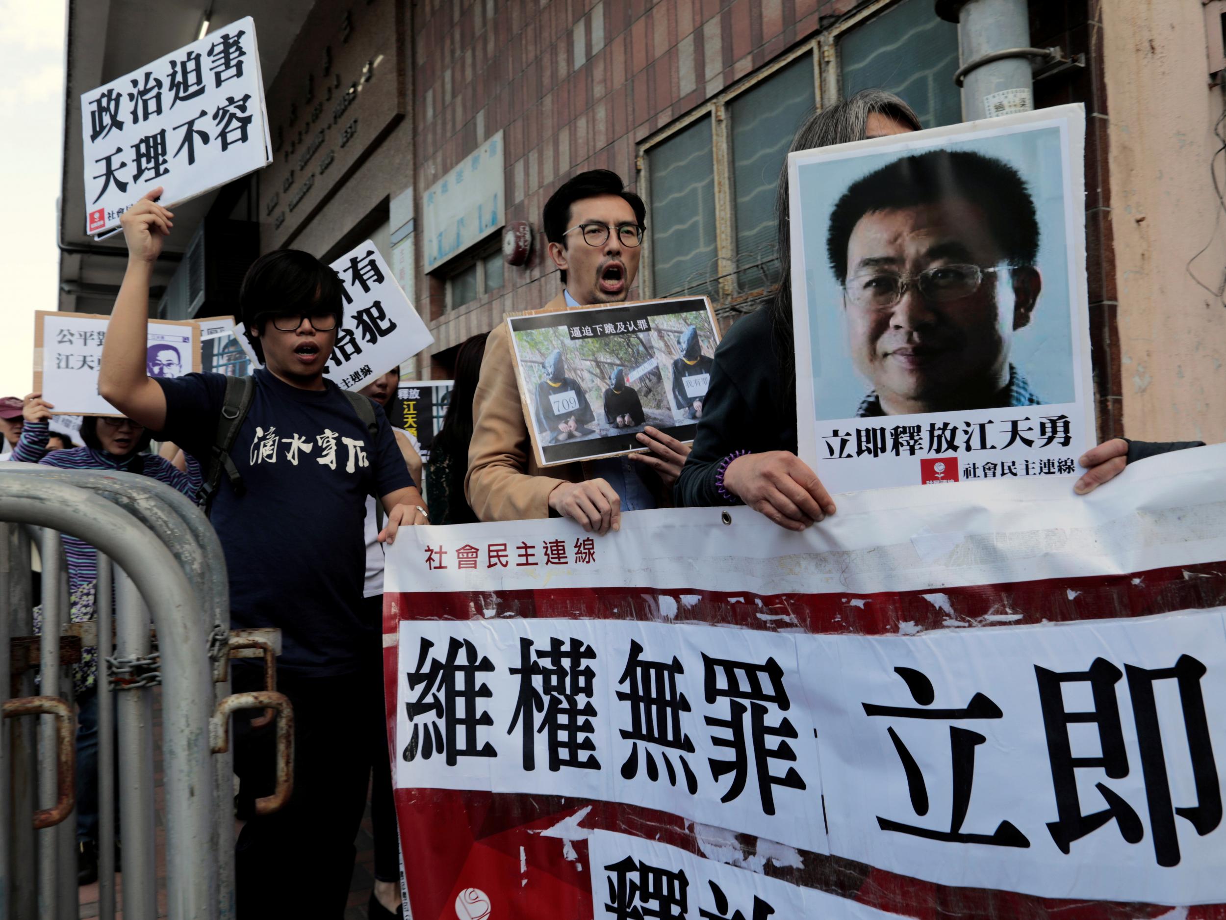 Pro-democracy demonstrators hold up portraits of disbarred lawyer Jiang Tianyong demanding his release outside the Chinese liaison office in Hong Kong