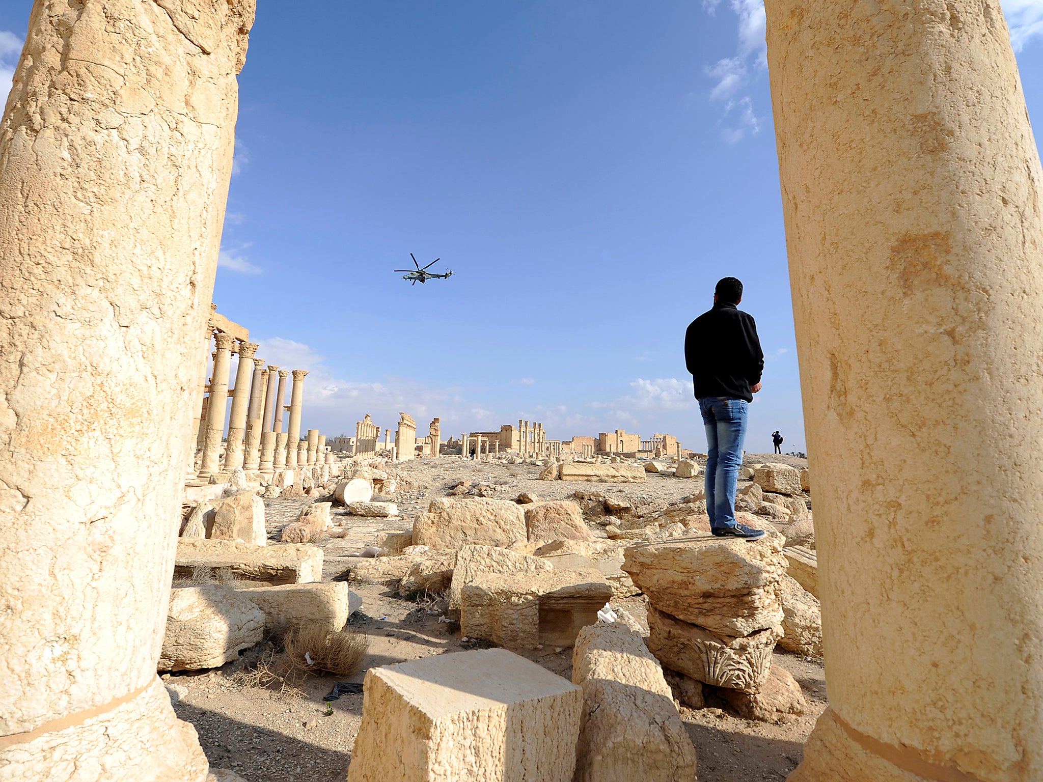 A Russian helicopter flies over ruins in the historic city of Palmyra