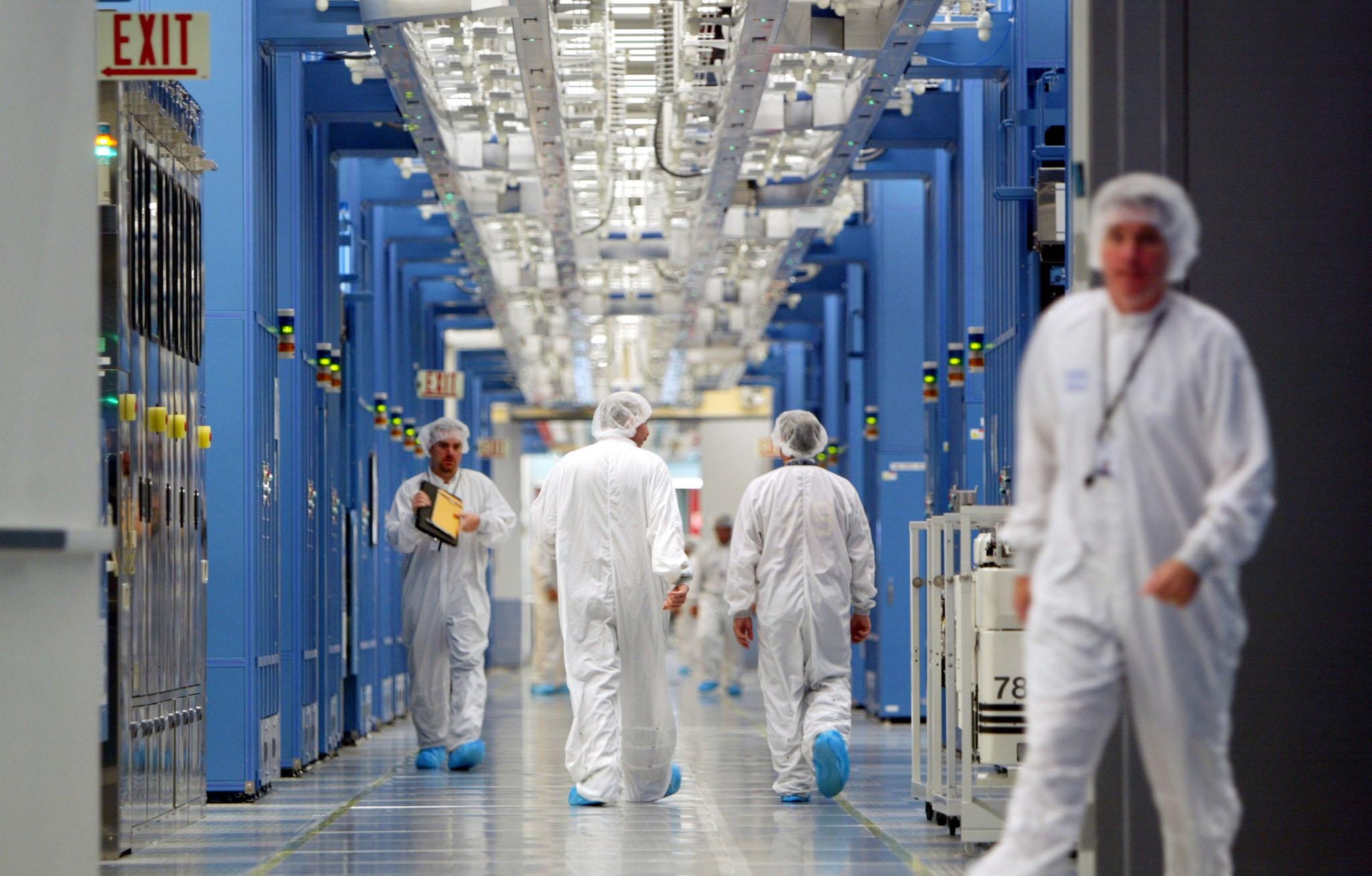 IBM workers walk in an IBM 12-inch wafer chip fabricating plant July 20, 2004 in Fishkill, New York