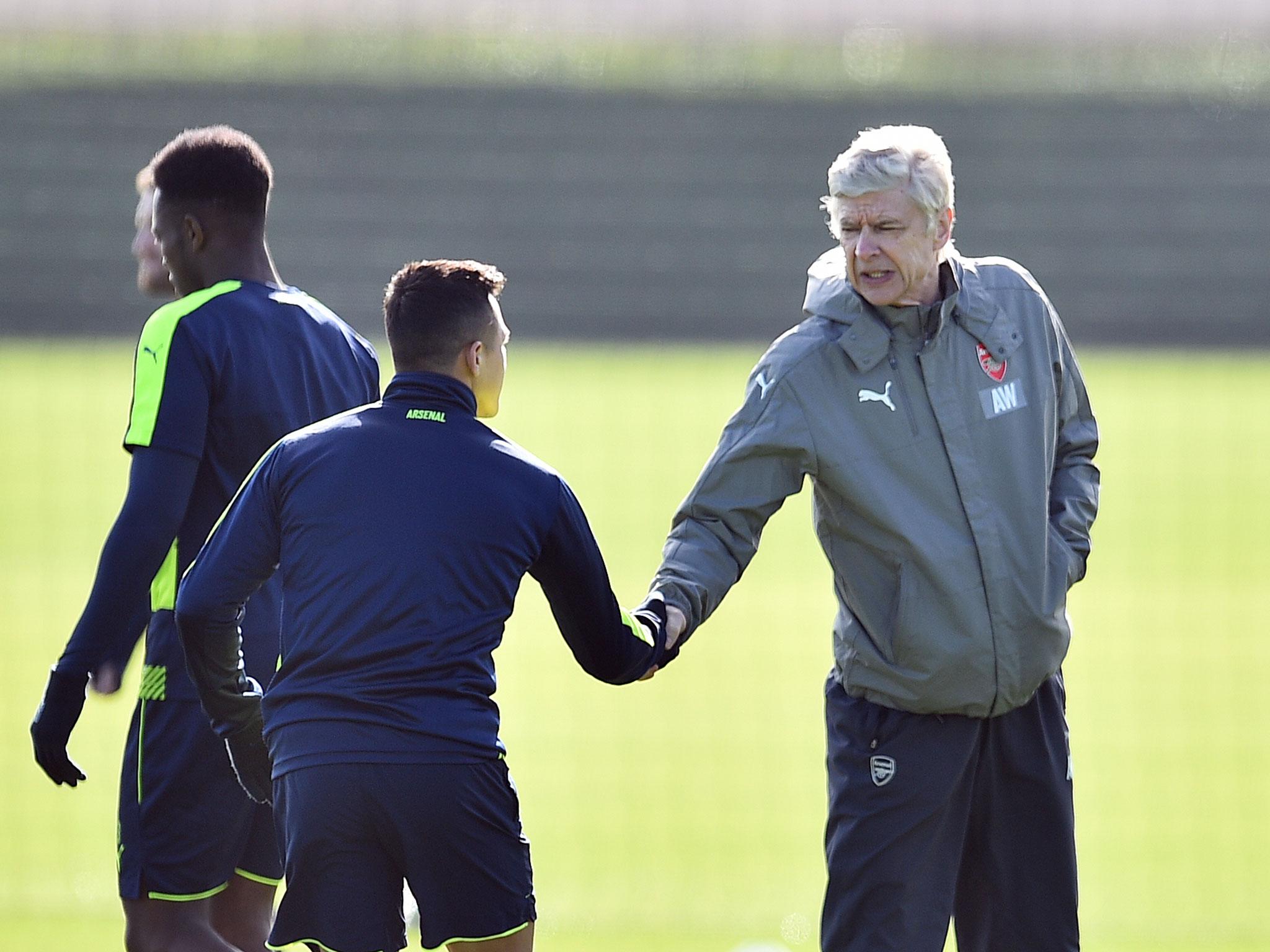 Alexis Sanchez shakes hands with Arsene Wenger during Arsenal training on Monday