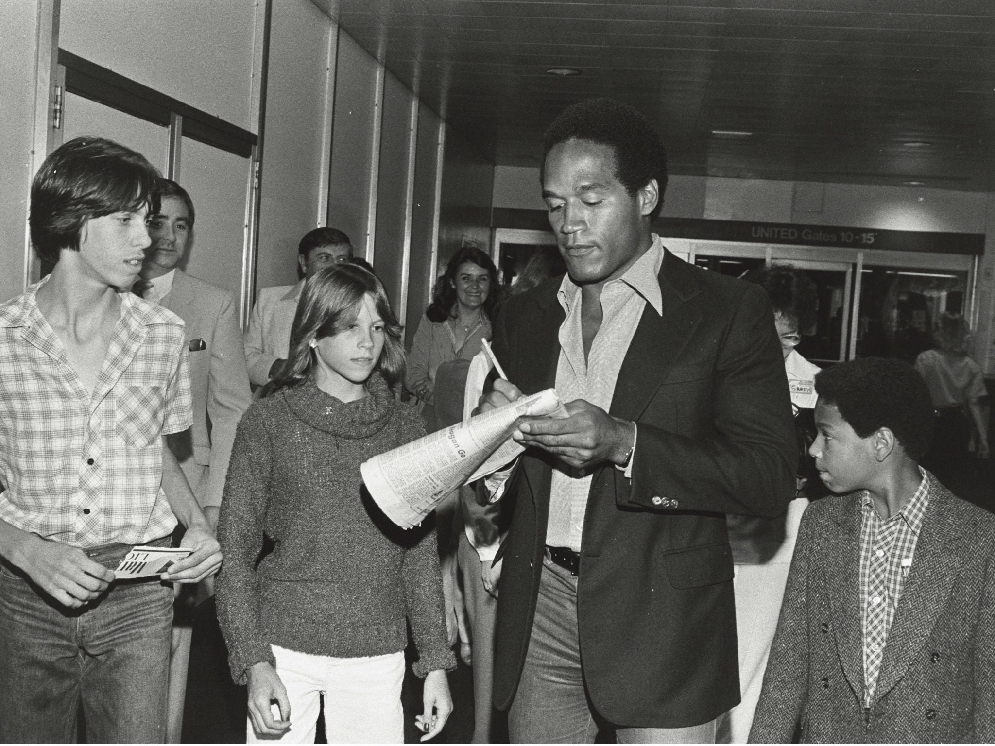 Simpson signing autographs with his son Jason (right) in 1980