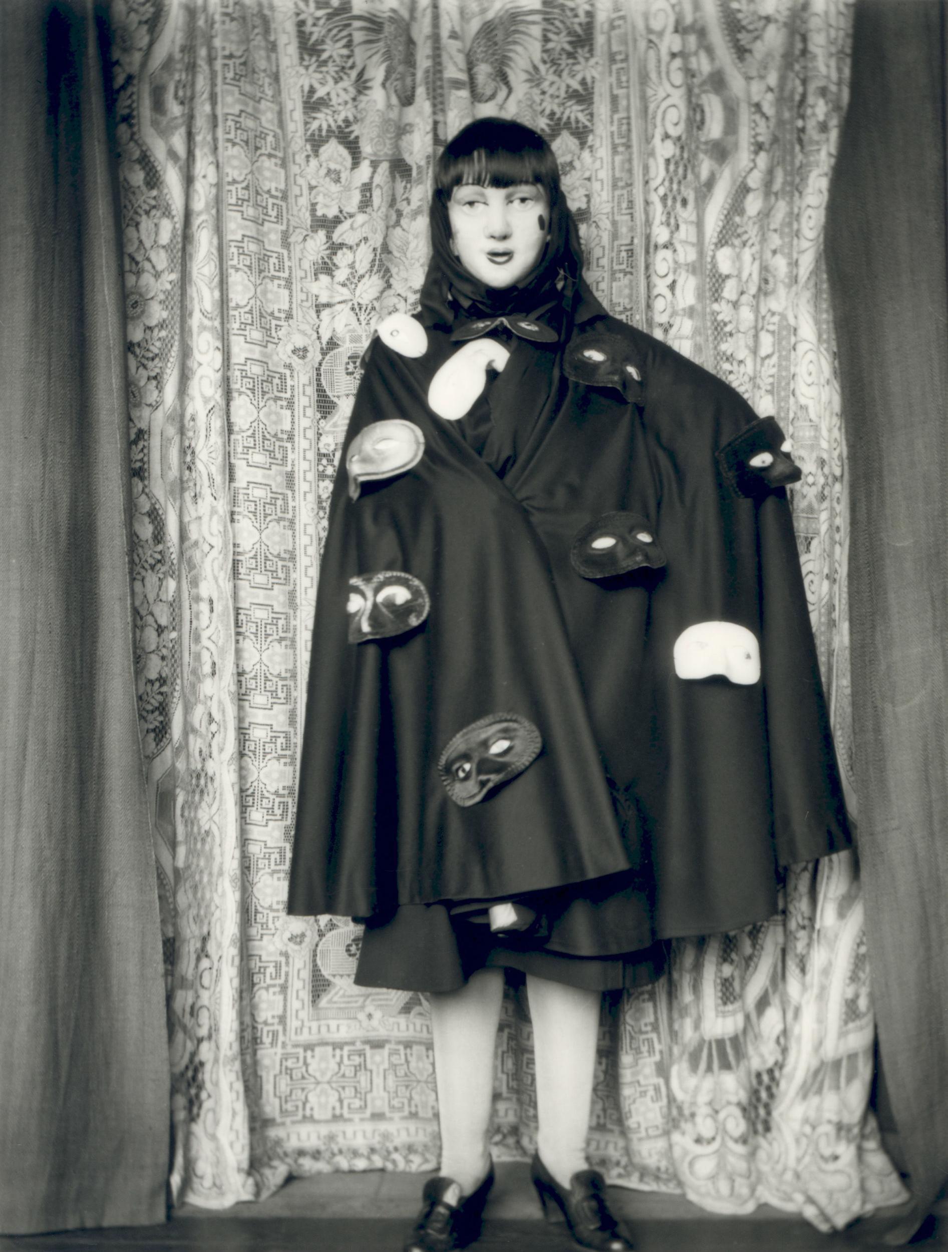 'Self-portrait (full length masked figure in cloak with masks)' by Claude Cahun, 1928