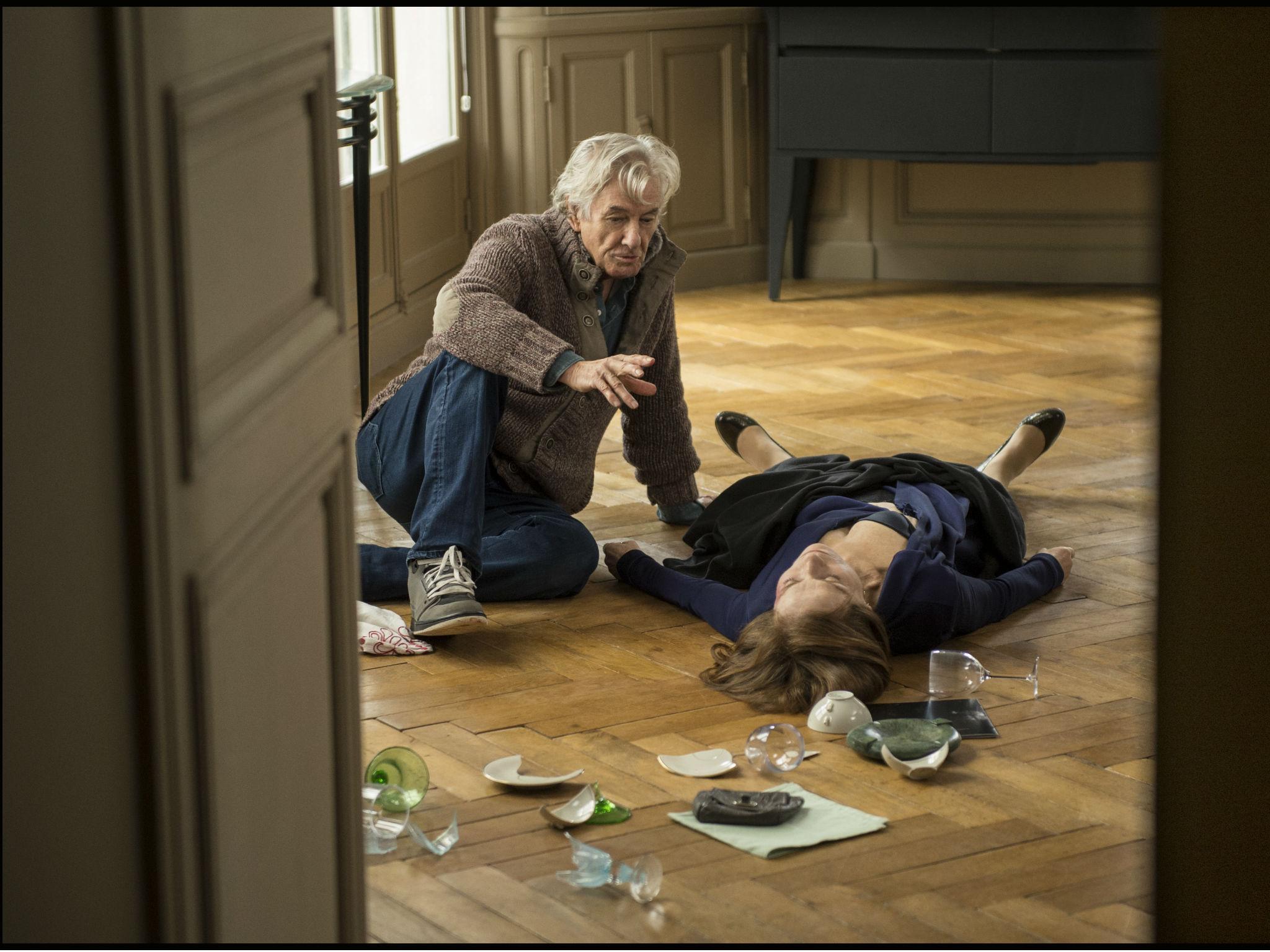 Isabelle Huppert (Michéle) lying on the floor receiving instruction from director Paul Verhoeven in 'Elle'