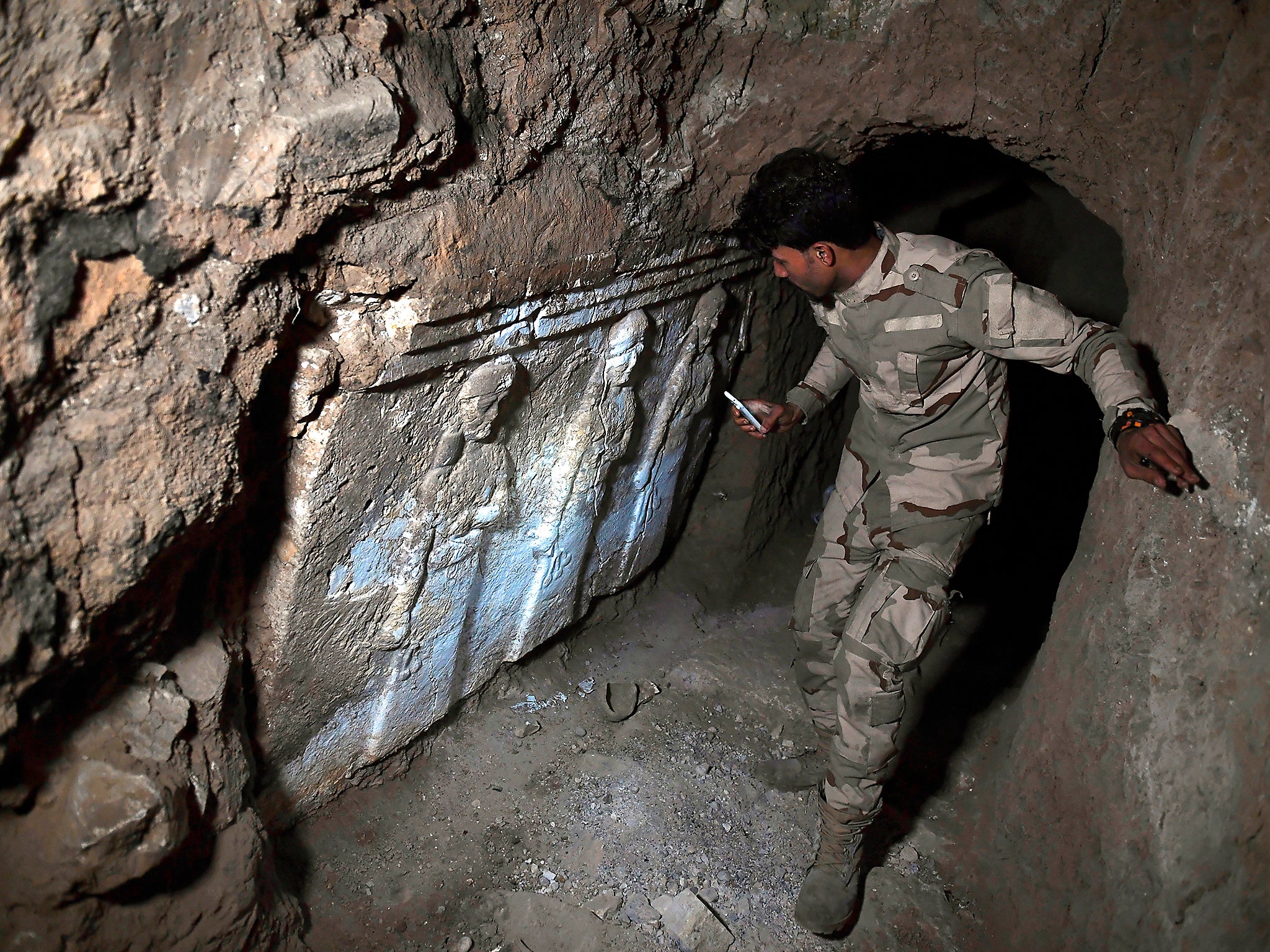 An Iraqi soldier can be seen exploring one of the recently found tunnels beneath the Prophet Jonah's shrine