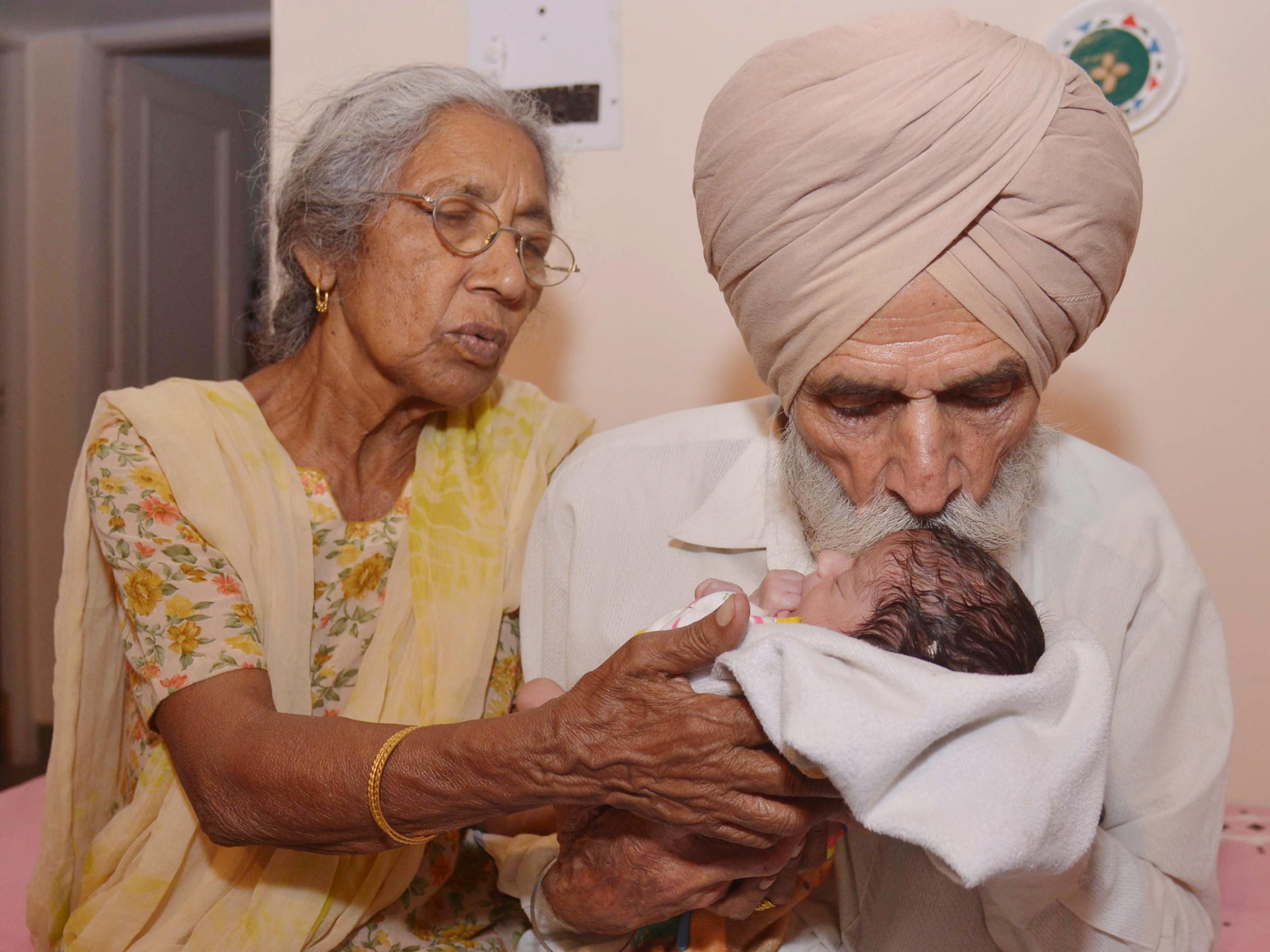 Indian father Mohinder Singh Gill, 79, and his wife Daljinder Kaur, 72, pose for a photograph as they hold their newborn baby boy Arman at their home in Amritsar on May 11, 2016