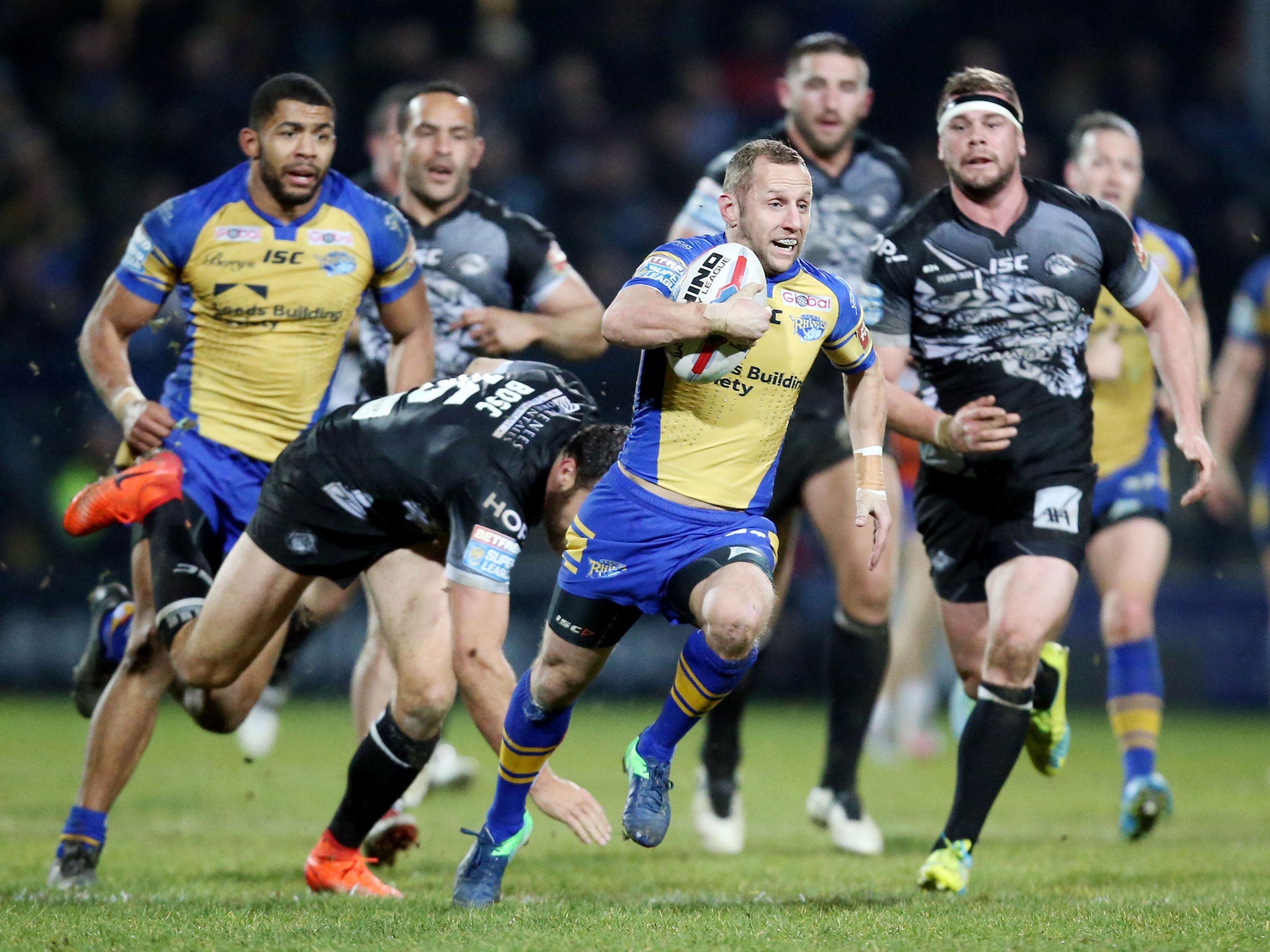 Rob Burrow breaks free of a tackle to score for Leeds