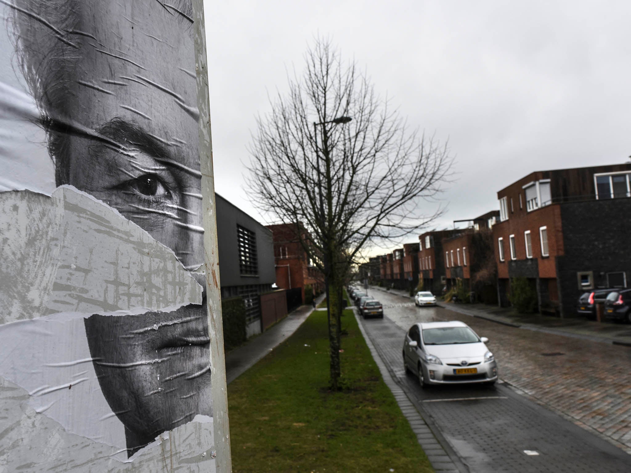 A torn political poster of Geert Wilders, a far right politician, looks over the IJburg neighborhood in Amsterdam