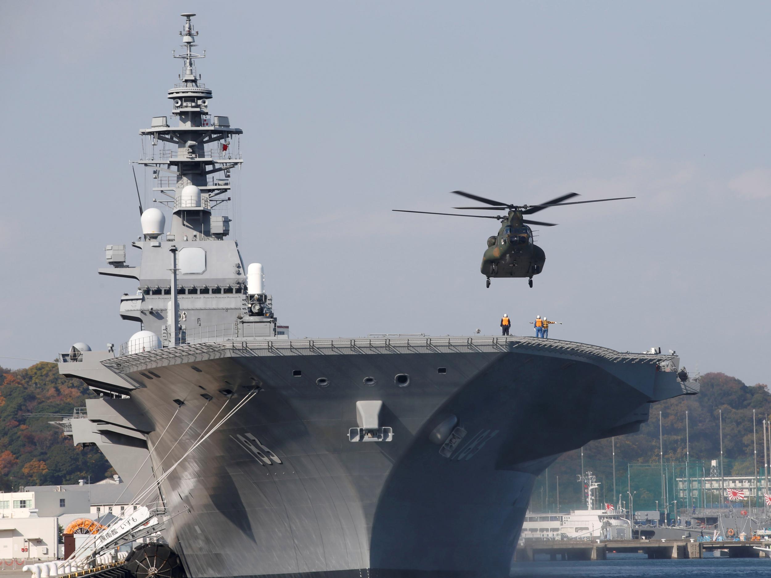 A helicopter lands on the Izumo, Japan Maritime Self Defence Force's (JMSDF) helicopter carrier, at JMSDF Yokosuka base in Yokosuka, south of Tokyo