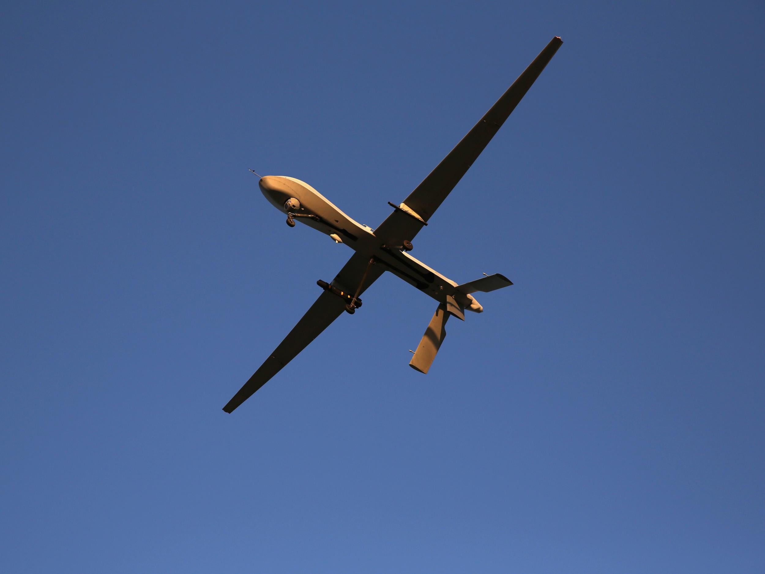 A US unmanned aerial vehicle carrying a Hellfire missile flies over an air base after flying a mission in the Persian Gulf region