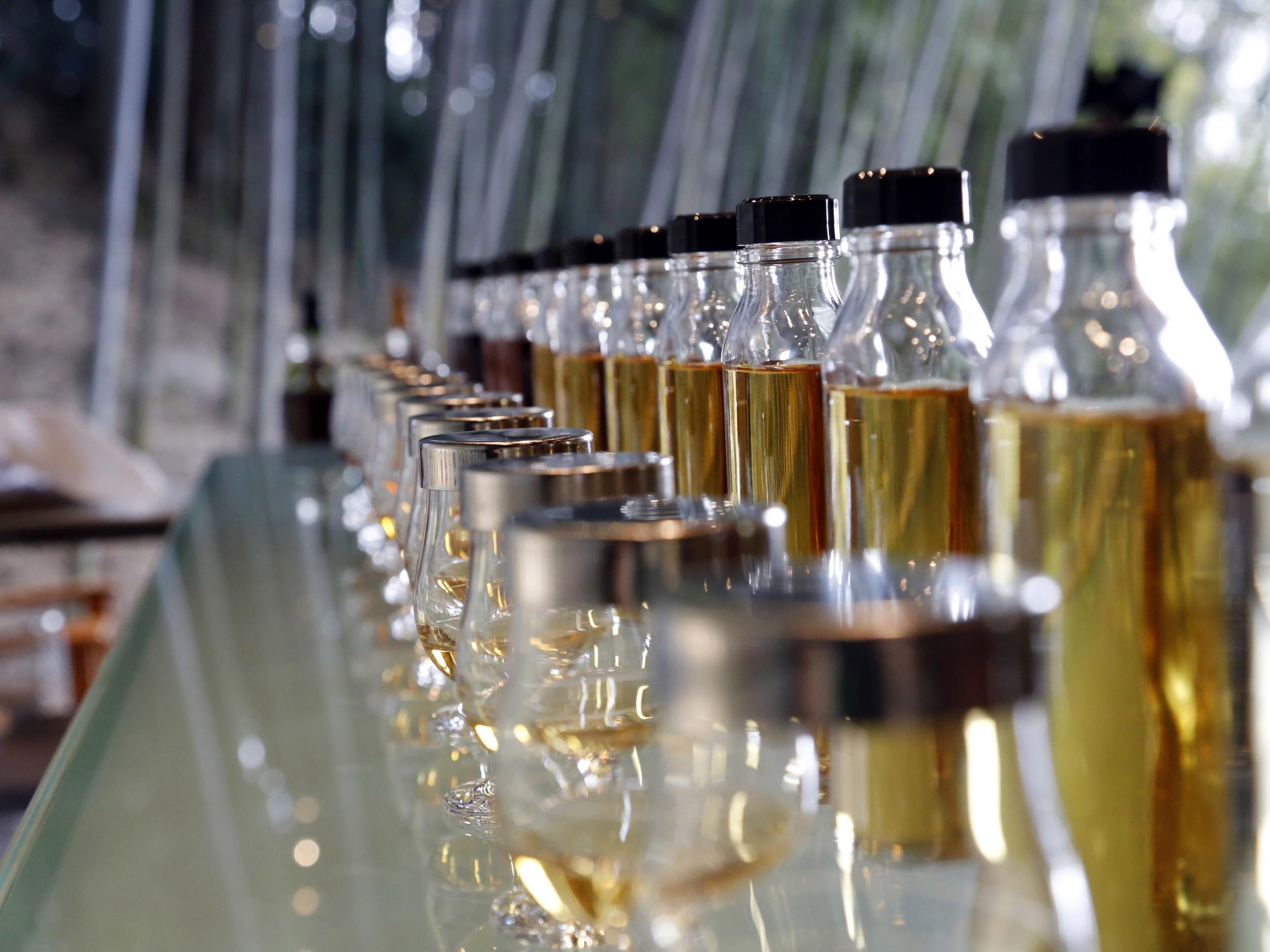 Various types of Suntory whisky line up on a counter for examination at the company's distillery, surrounded by bamboo groves, in Yamazaki near Kyoto